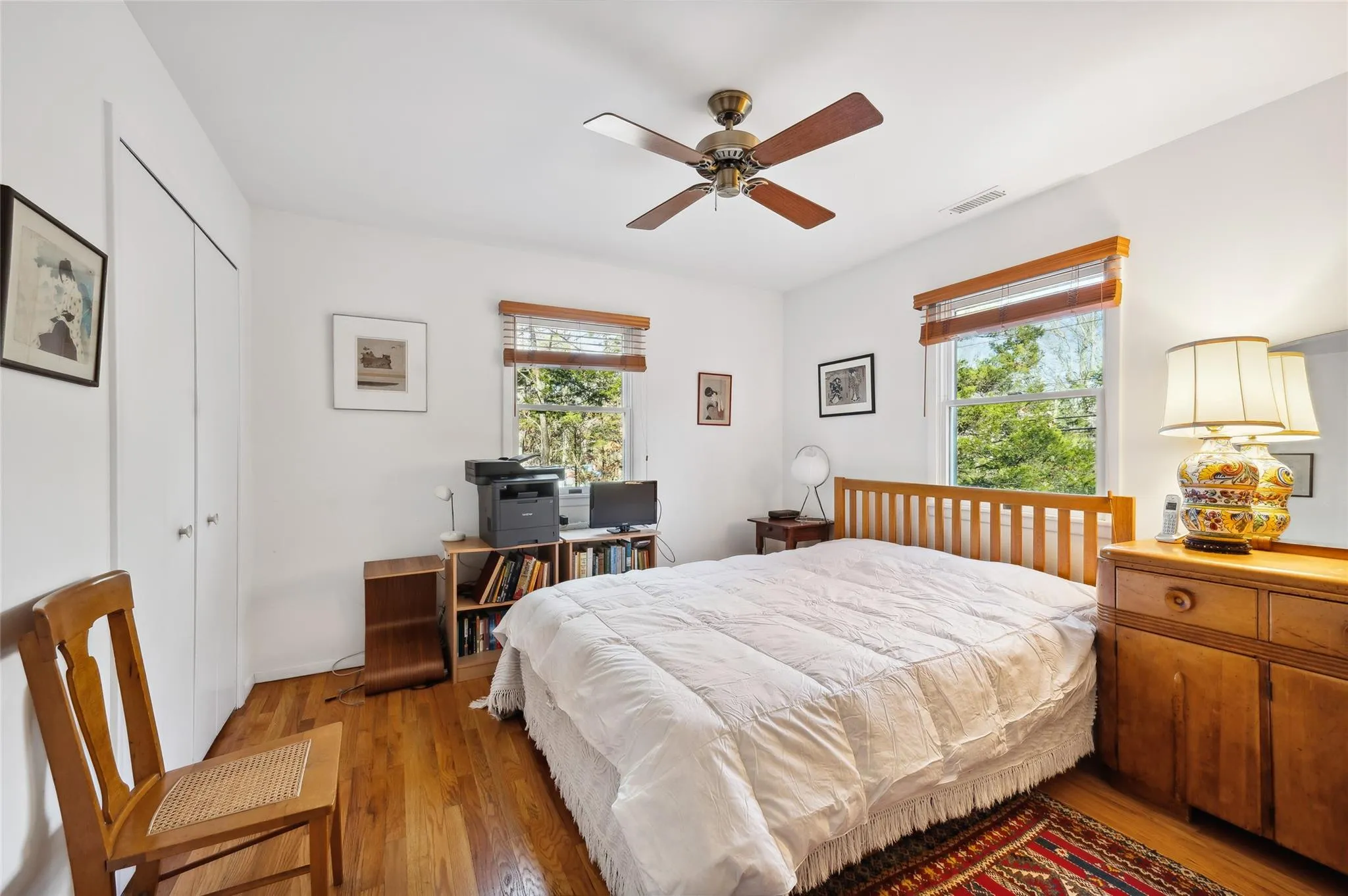 Bedroom featuring light wood-type flooring, a closet, multiple windows, and ceiling fan Bedroom featuring light wood-type flooring, a closet, multiple windows, and ceiling fan