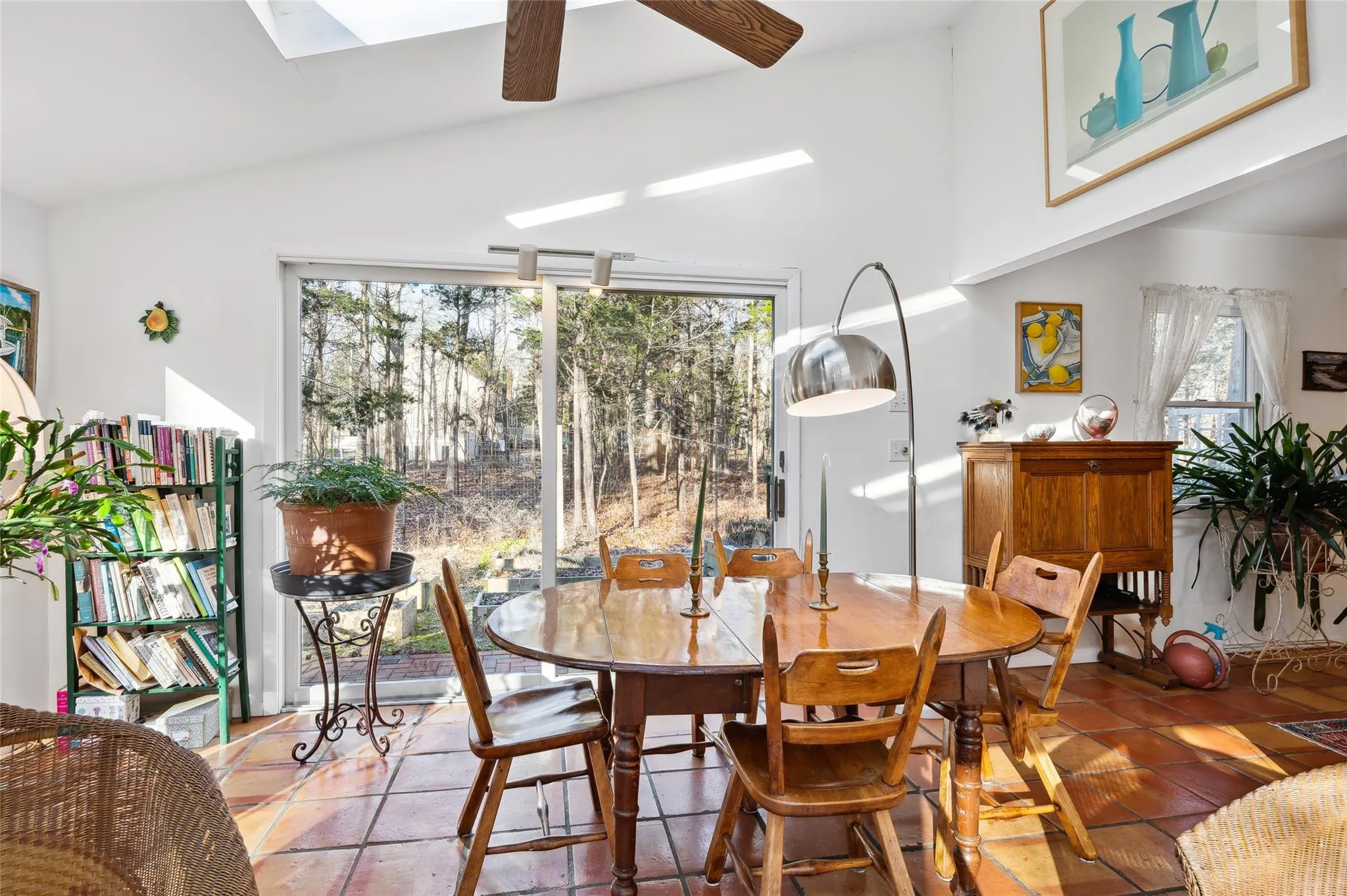Dining space featuring ceiling fan, vaulted ceiling with skylight, and tile patterned floors Dining space featuring ceiling fan, vaulted ceiling with skylight, and tile patterned floors