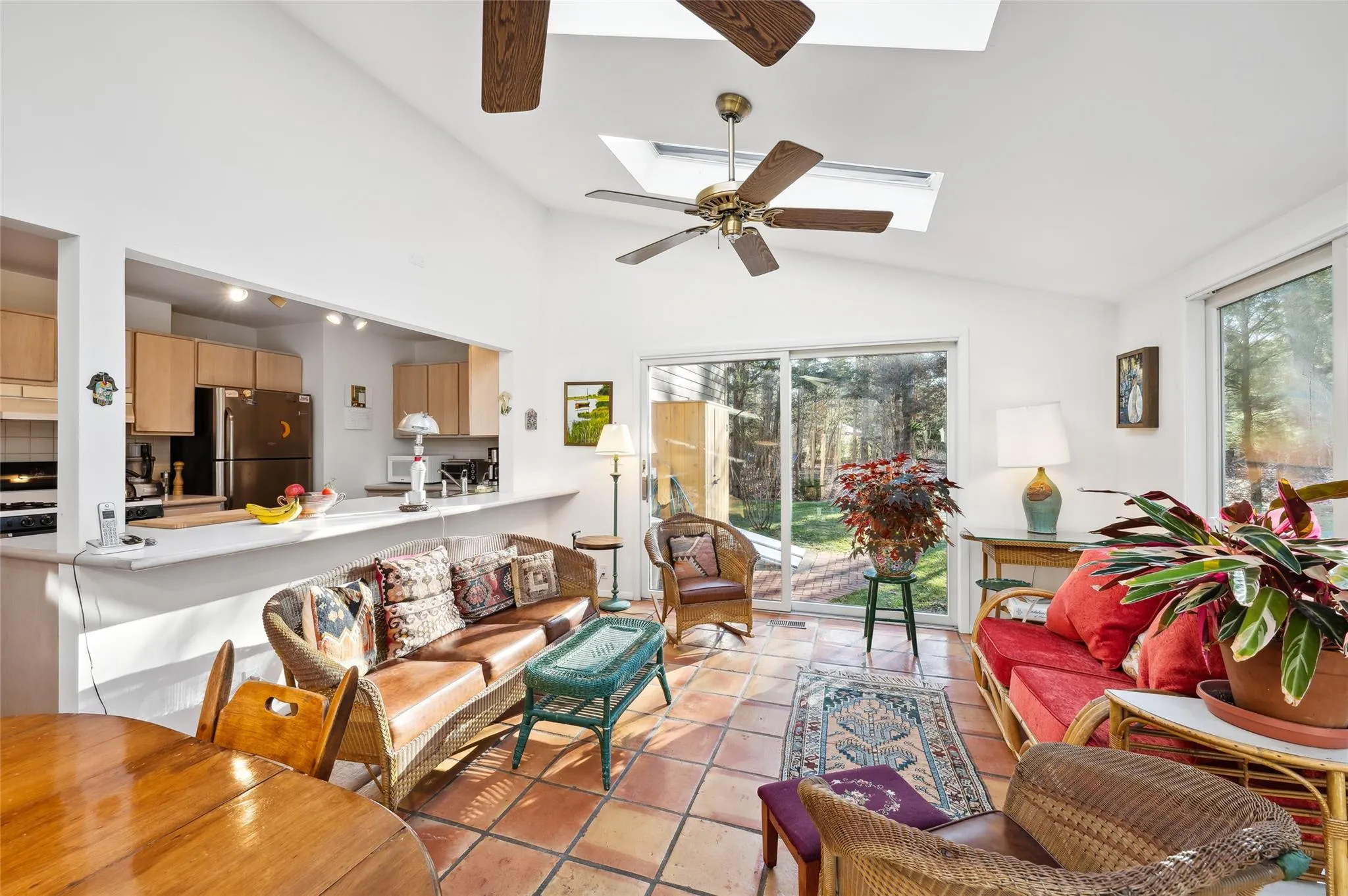 Tiled living room with ceiling fan and vaulted ceiling with skylight Tiled living room with ceiling fan and vaulted ceiling with skylight