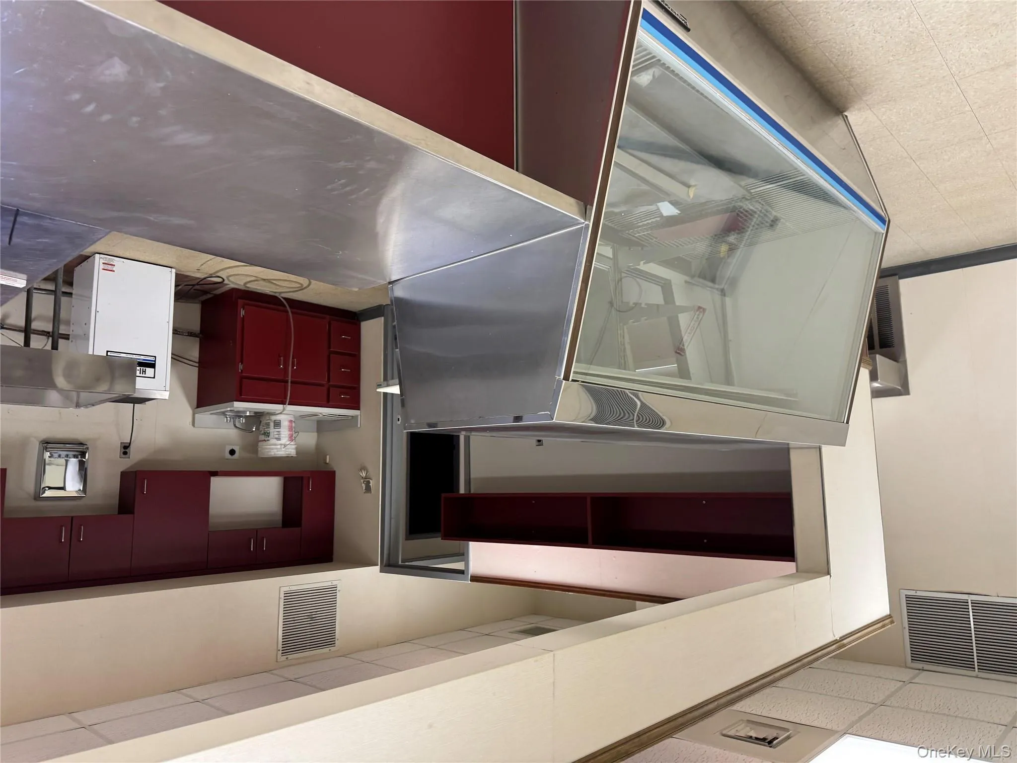 Kitchen with stainless steel counters, a drop ceiling, and refrigerator Kitchen with stainless steel counters, a drop ceiling, and refrigerator