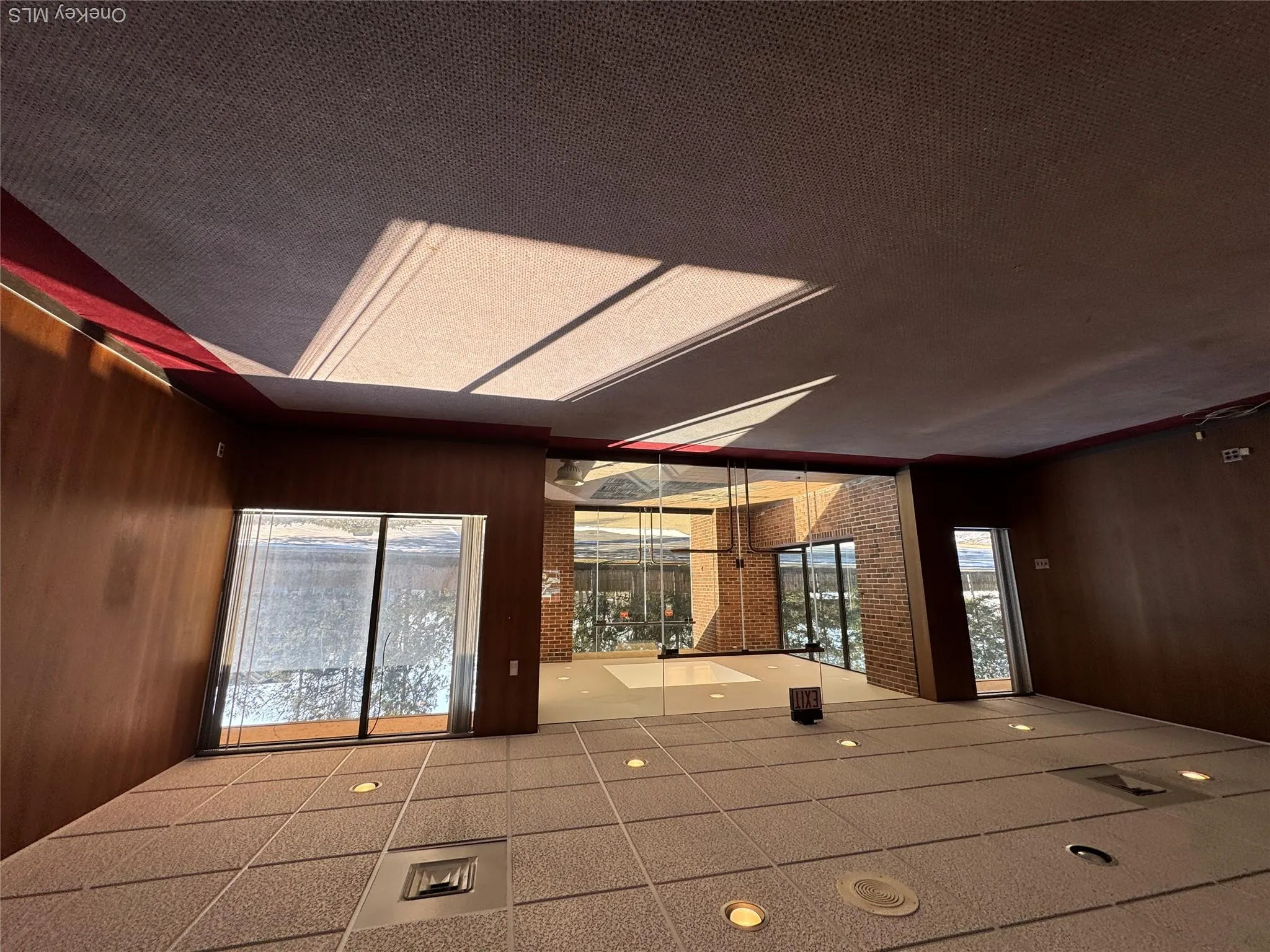 Unfurnished room featuring carpet floors, wooden walls, and a healthy amount of sunlight Unfurnished room featuring carpet floors, wooden walls, and a healthy amount of sunlight