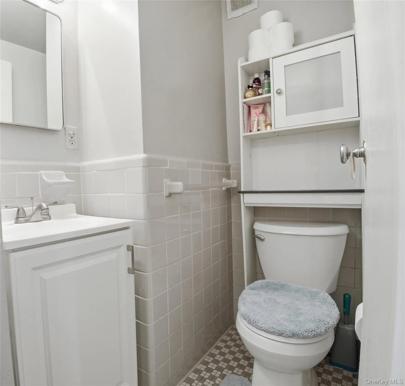 Half bathroom featuring tile walls, a wainscoted wall, and vanity Half bathroom featuring tile walls, a wainscoted wall, and vanity