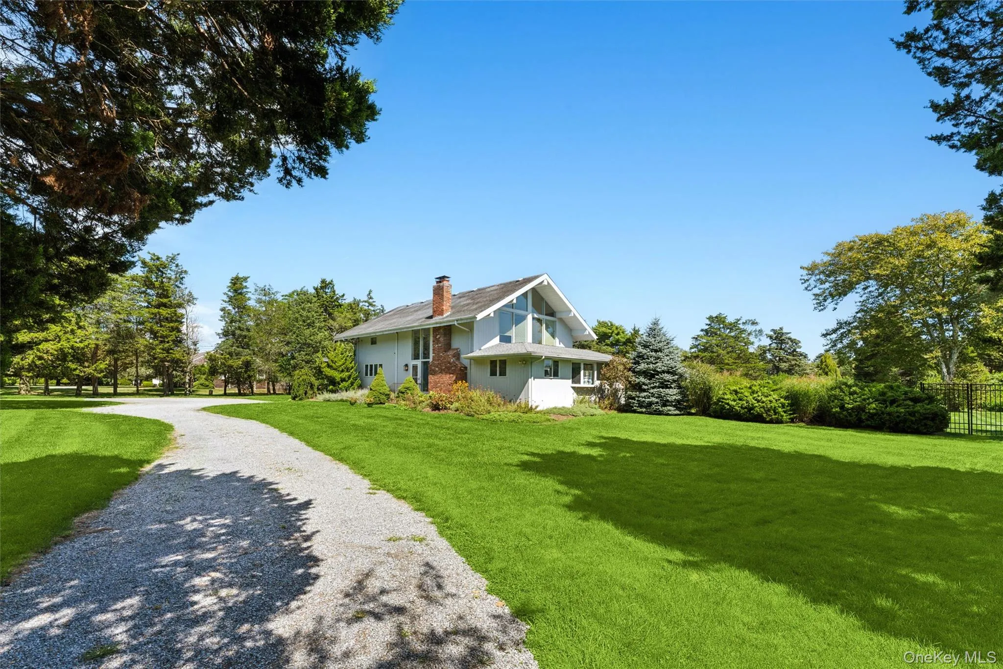 View of side of home featuring a chimney and driveway View of side of home featuring a chimney and driveway