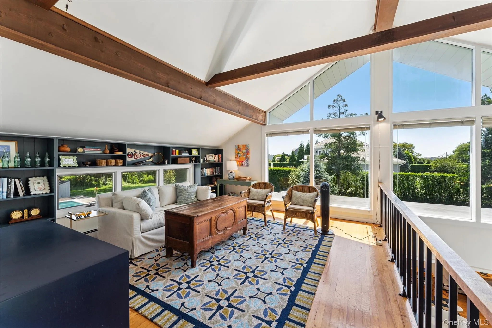Living area with beam ceiling, light wood-style flooring, and high vaulted ceiling Living area with beam ceiling, light wood-style flooring, and high vaulted ceiling