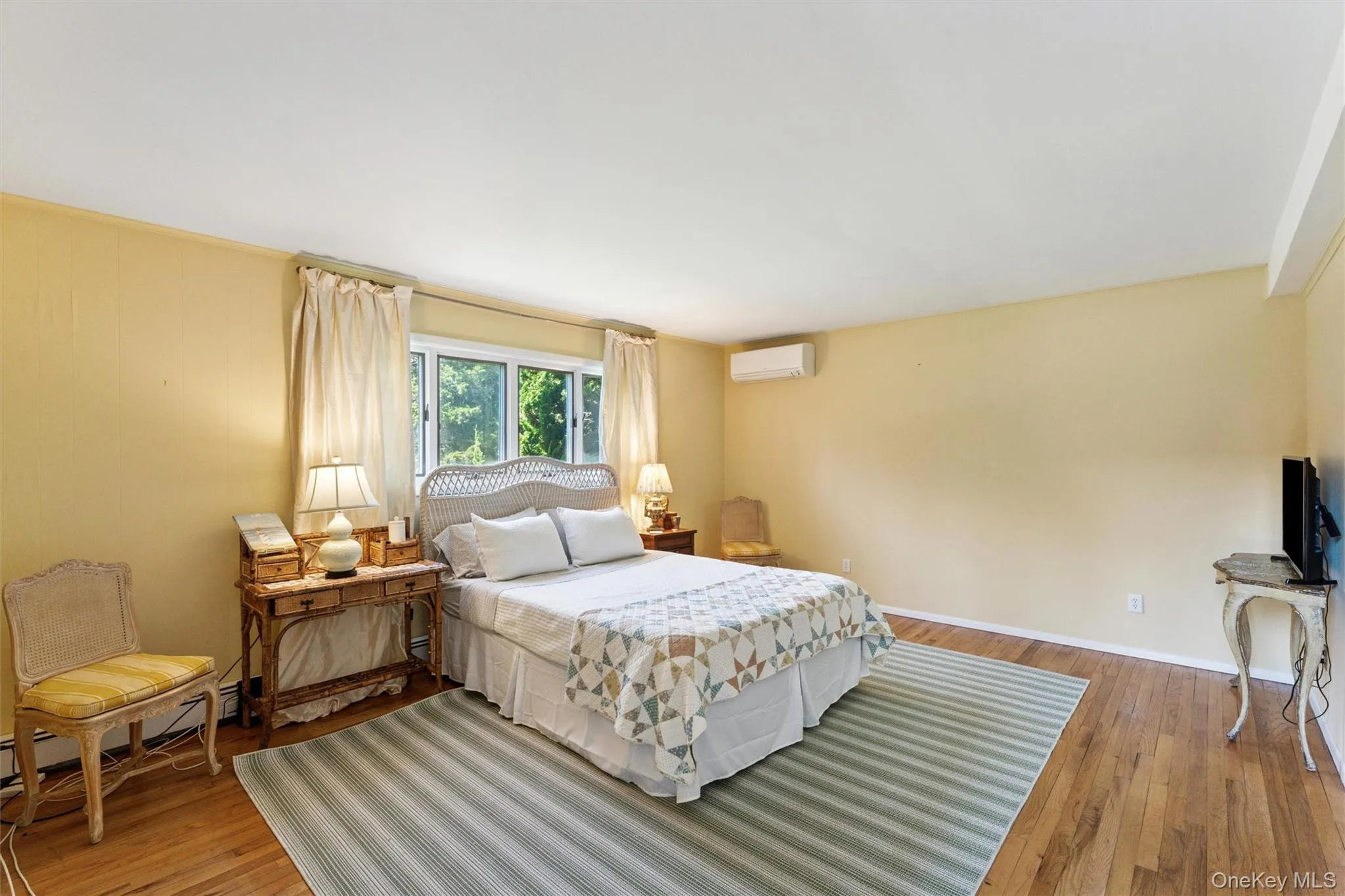 Bedroom with hardwood / wood-style flooring and a wall mounted AC Bedroom with hardwood / wood-style flooring and a wall mounted AC