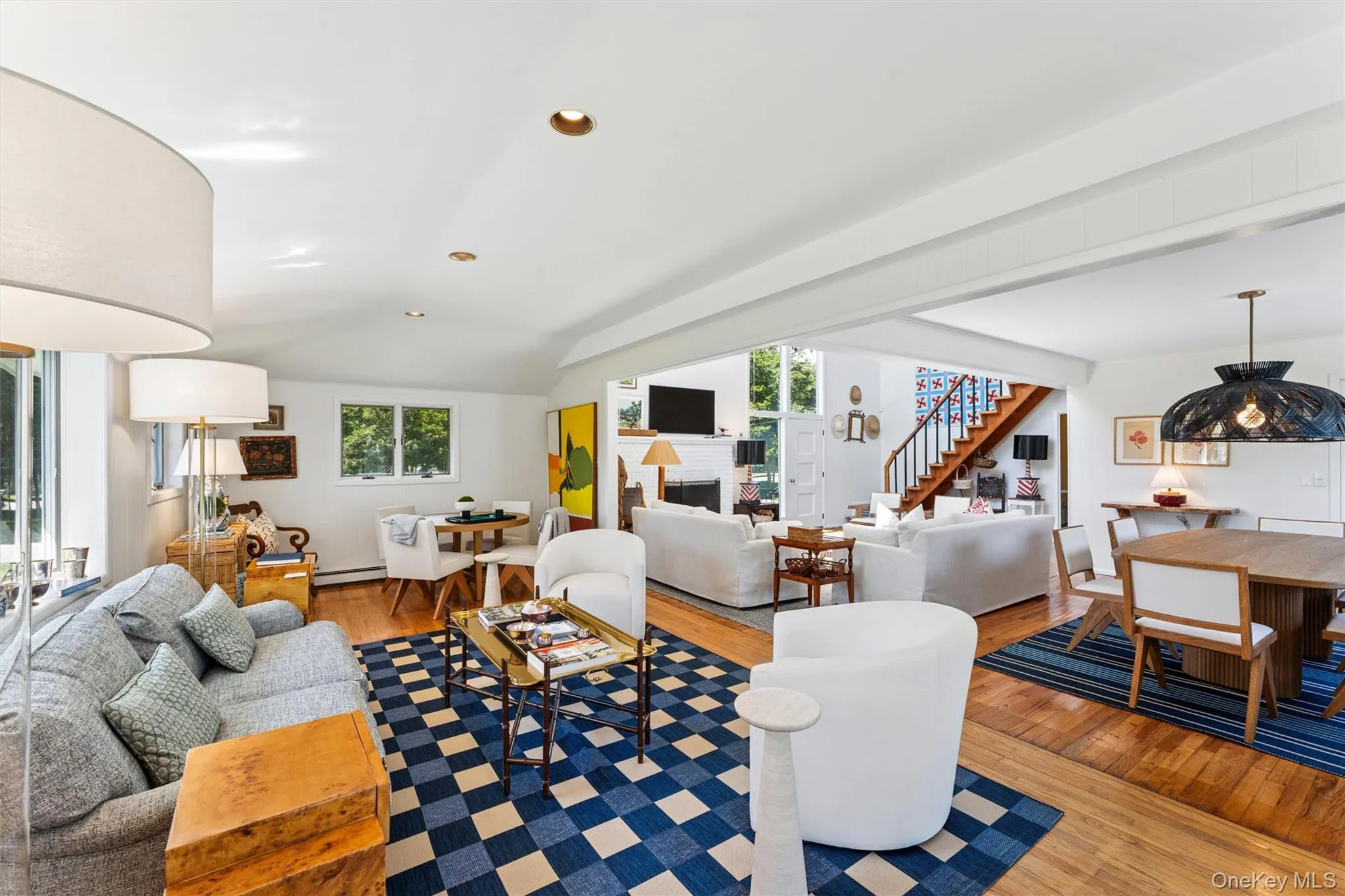 Living area featuring plenty of natural light, light wood-type flooring, recessed lighting, stairs, and vaulted ceiling Living area featuring plenty of natural light, light wood-type flooring, recessed lighting, stairs, and vaulted ceiling