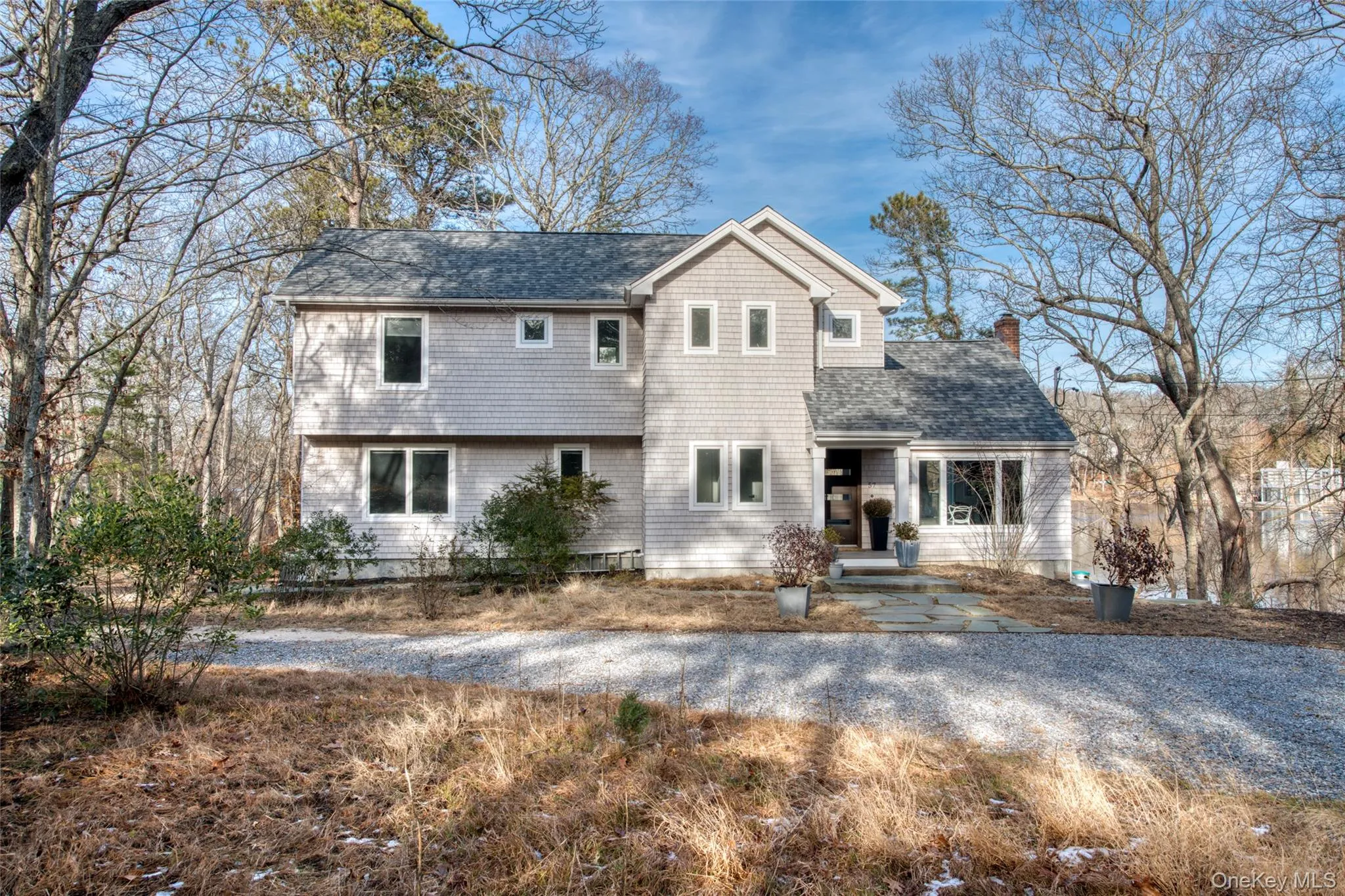 View of front of house featuring a shingled roof and a chimney View of front of house featuring a shingled roof and a chimney