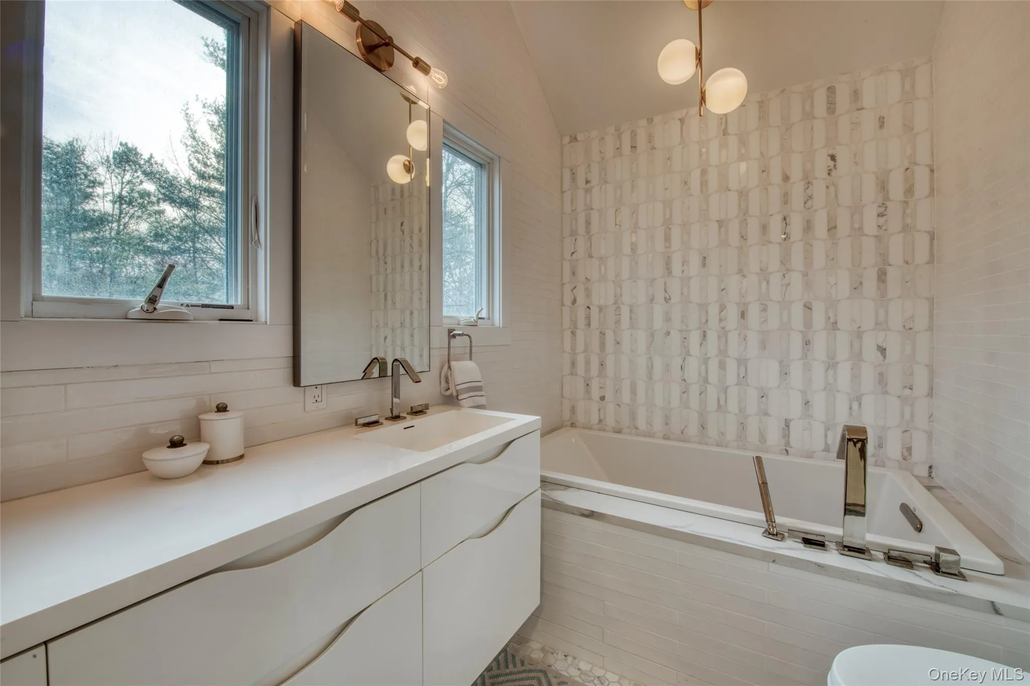 Full bathroom with lofted ceiling, tiled tub, and vanity Full bathroom with lofted ceiling, tiled tub, and vanity