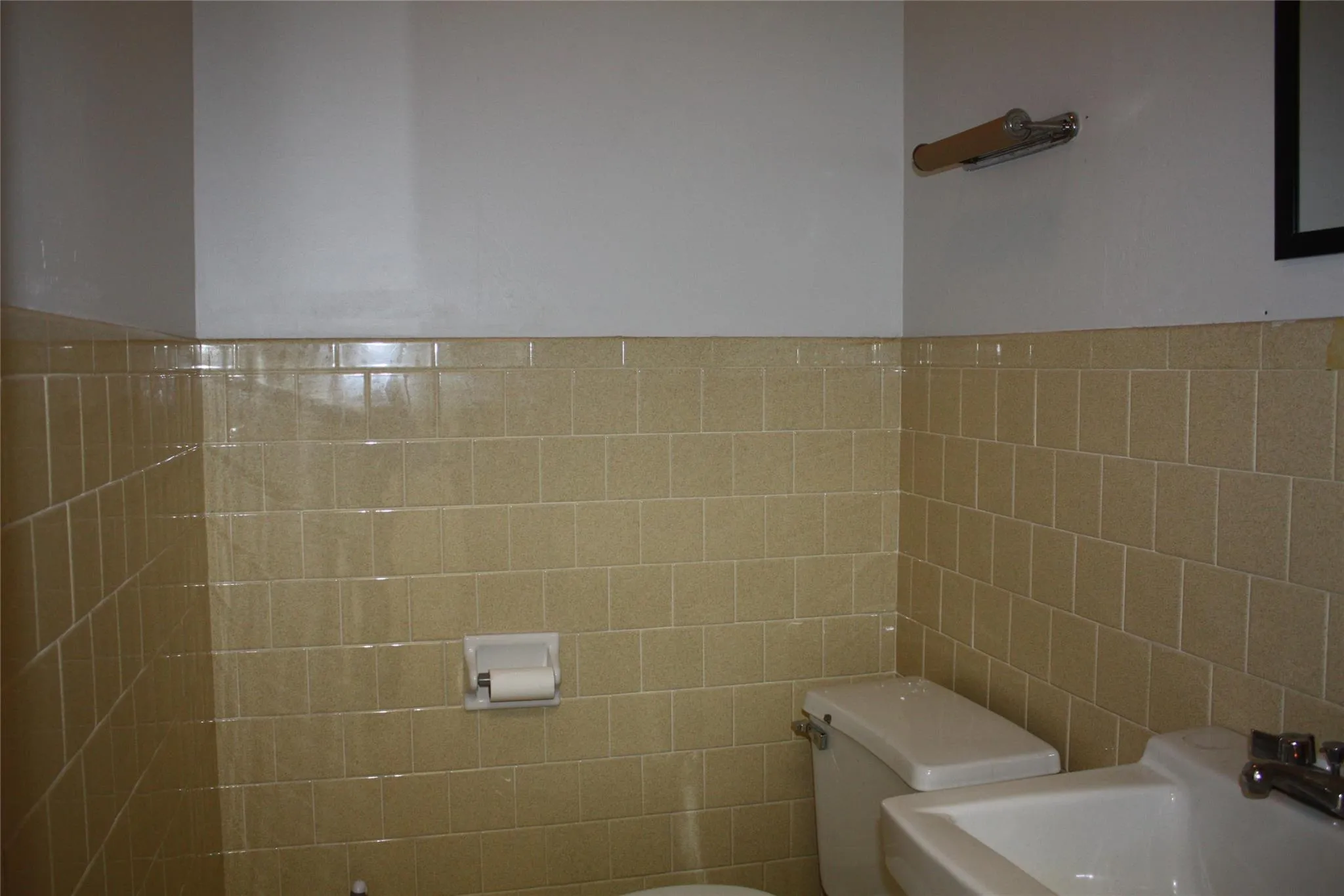 Bathroom with sink, toilet, and tile walls Bathroom with sink, toilet, and tile walls