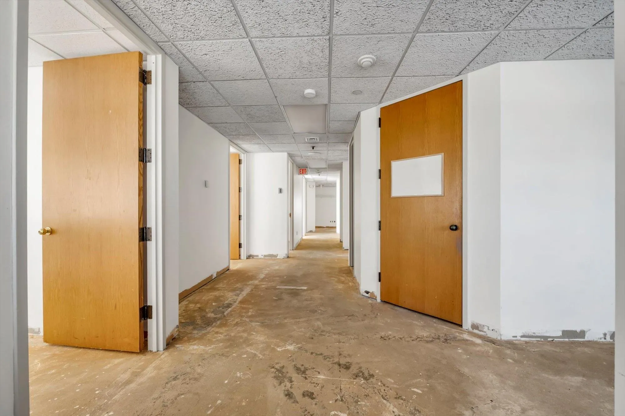 Corridor featuring a drop ceiling and concrete flooring Corridor featuring a drop ceiling and concrete flooring