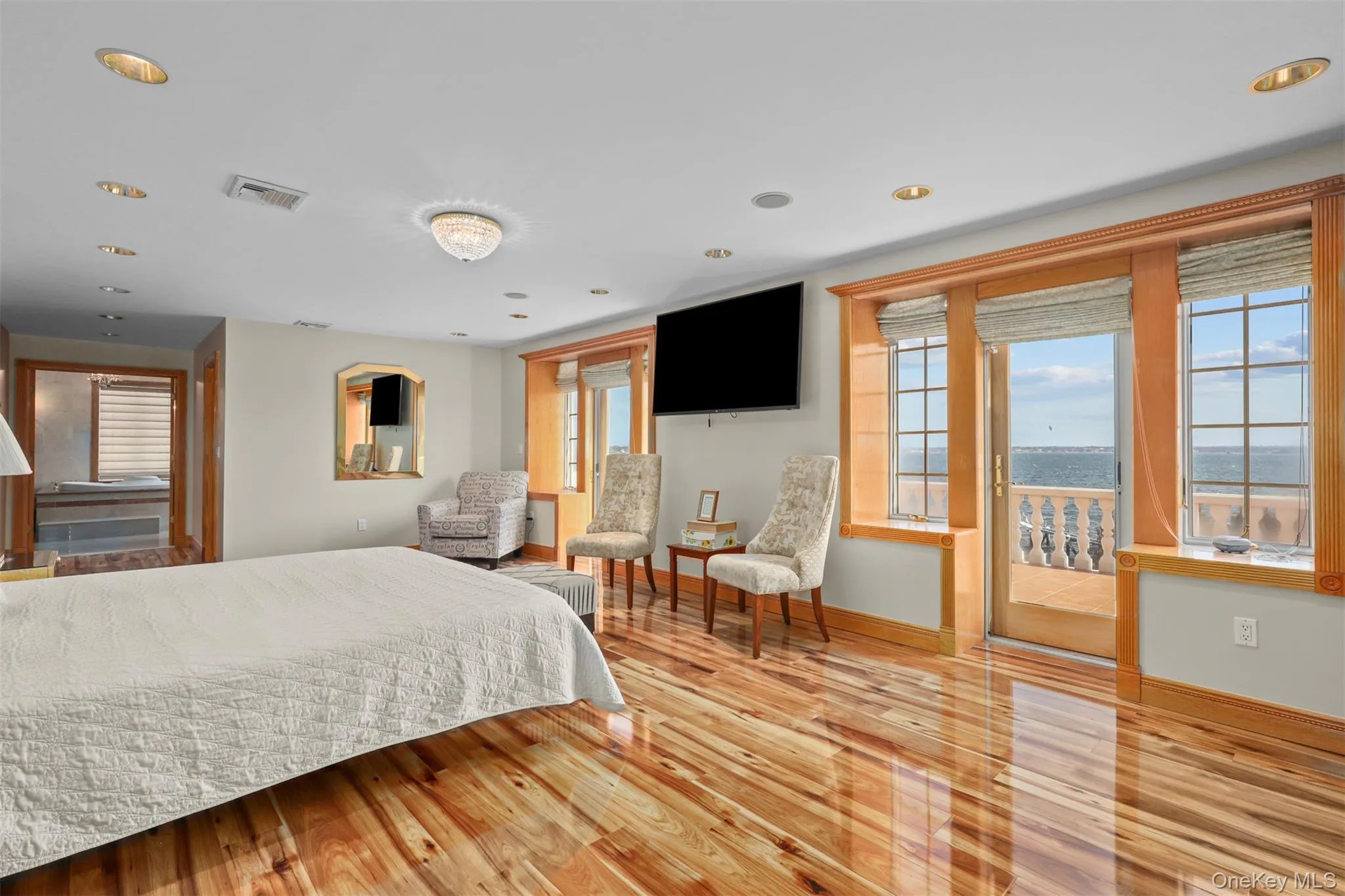 Bedroom featuring visible vents, multiple windows, baseboards, and wood finished floors Bedroom featuring visible vents, multiple windows, baseboards, and wood finished floors