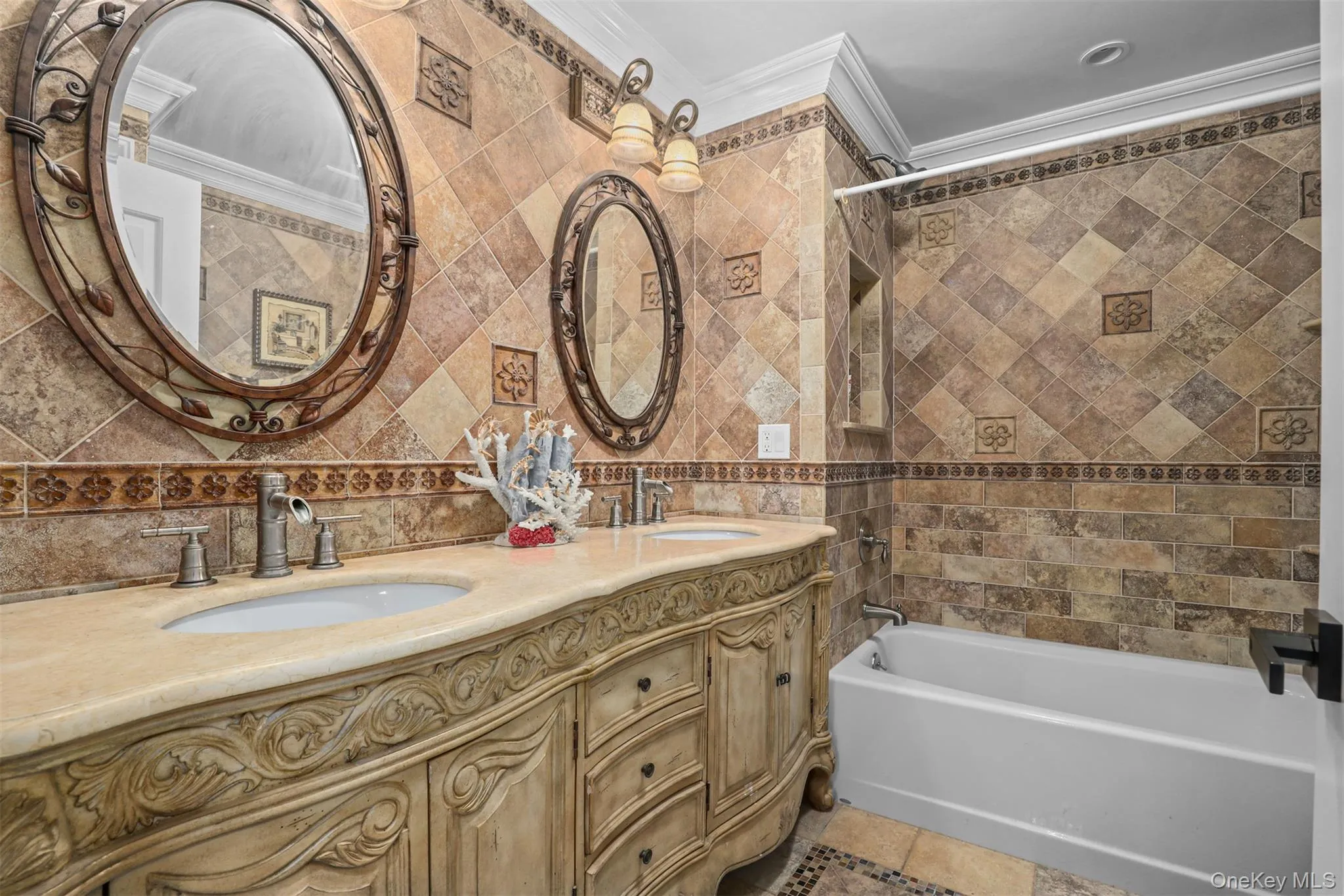 Bathroom featuring tile walls, crown molding, and a sink Bathroom featuring tile walls, crown molding, and a sink