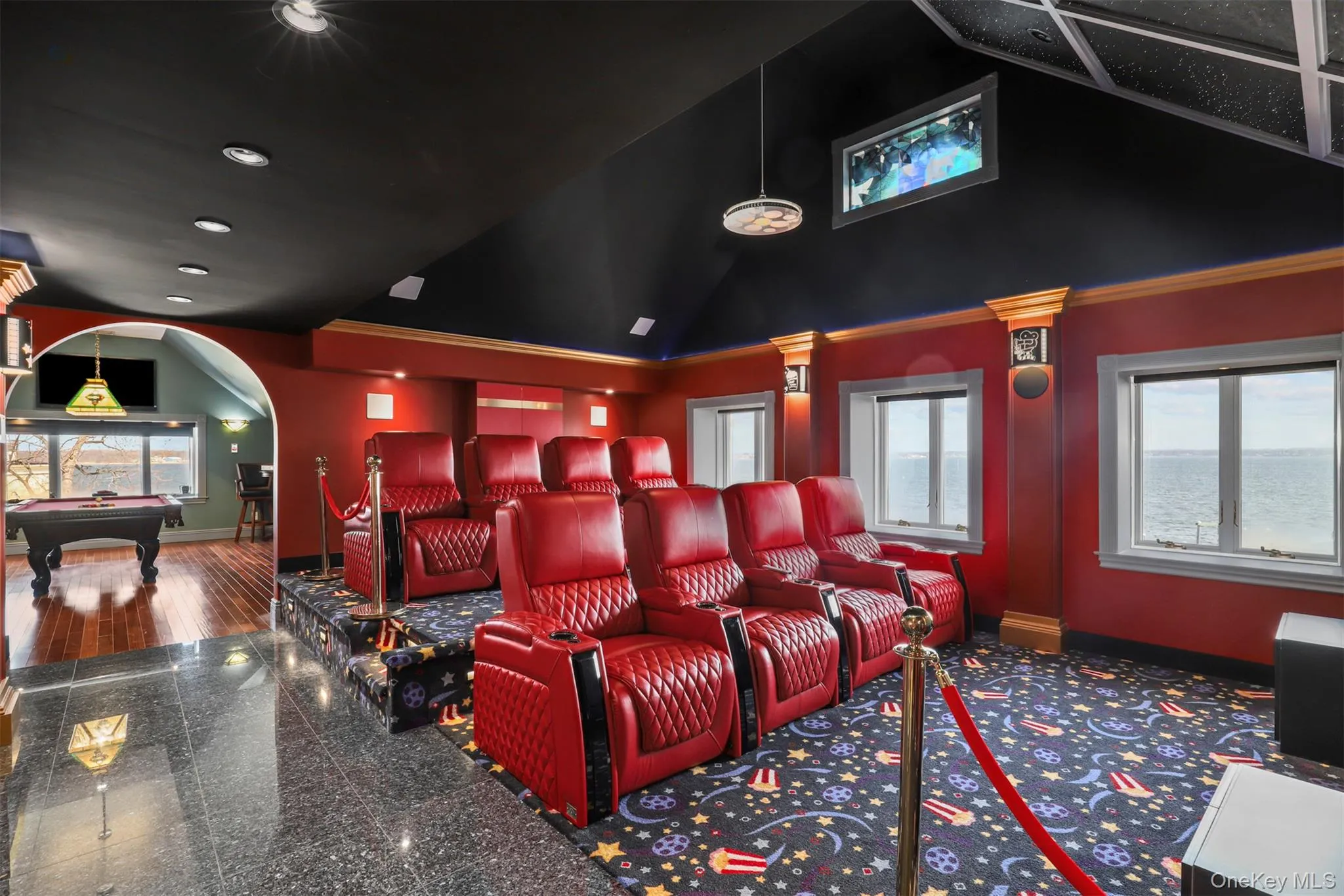 Cinema with billiards, arched walkways, baseboards, and high vaulted ceiling Cinema with billiards, arched walkways, baseboards, and high vaulted ceiling