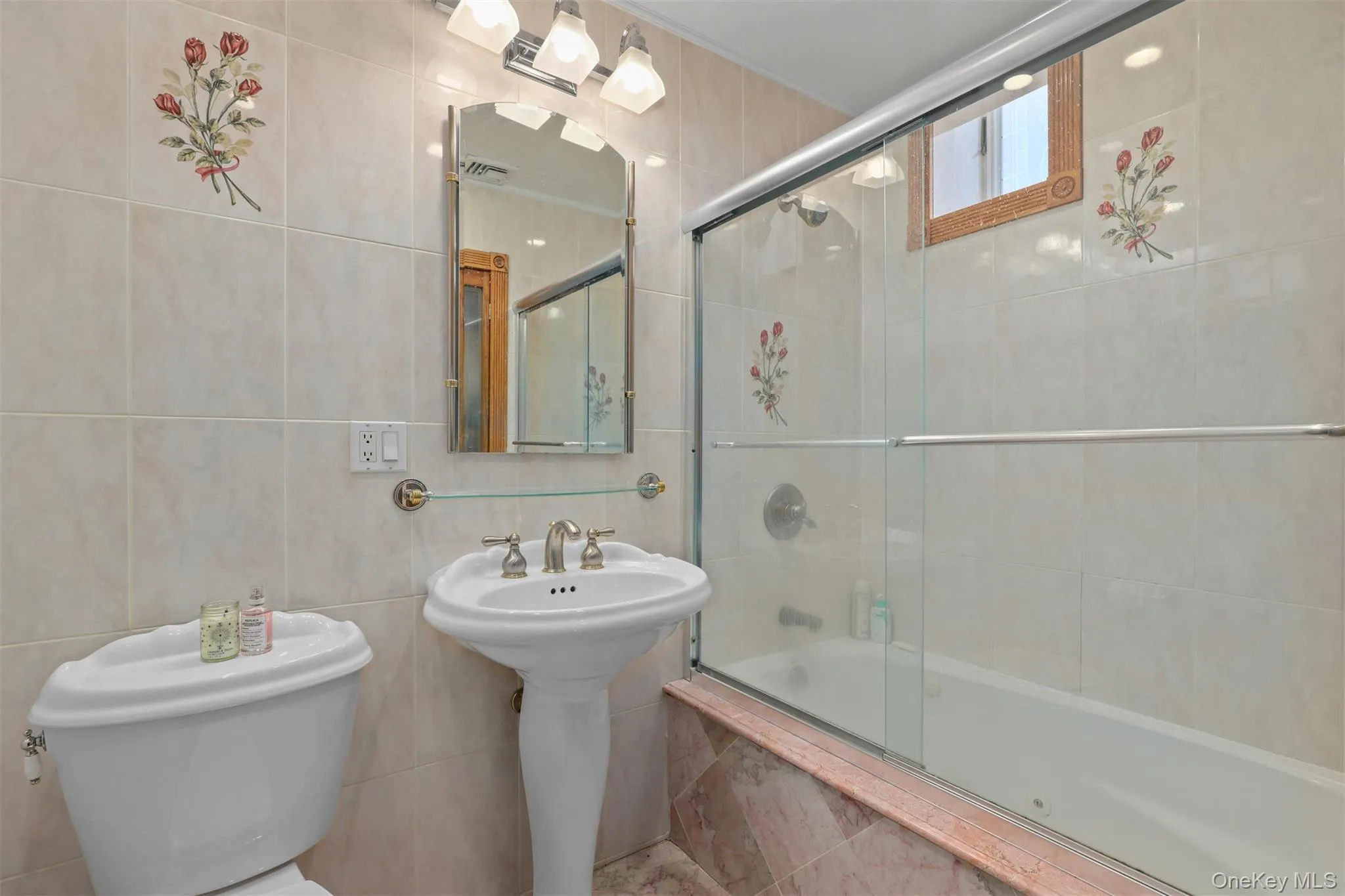 Bathroom with toilet, tile walls, and tiled shower / bath combo Bathroom with toilet, tile walls, and tiled shower / bath combo