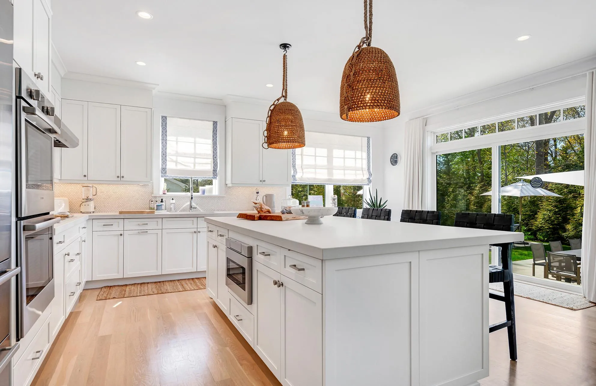 Kitchen featuring white cabinetry, decorative light fixtures, a breakfast bar, and a kitchen island Kitchen featuring white cabinetry, decorative light fixtures, a breakfast bar, and a kitchen island