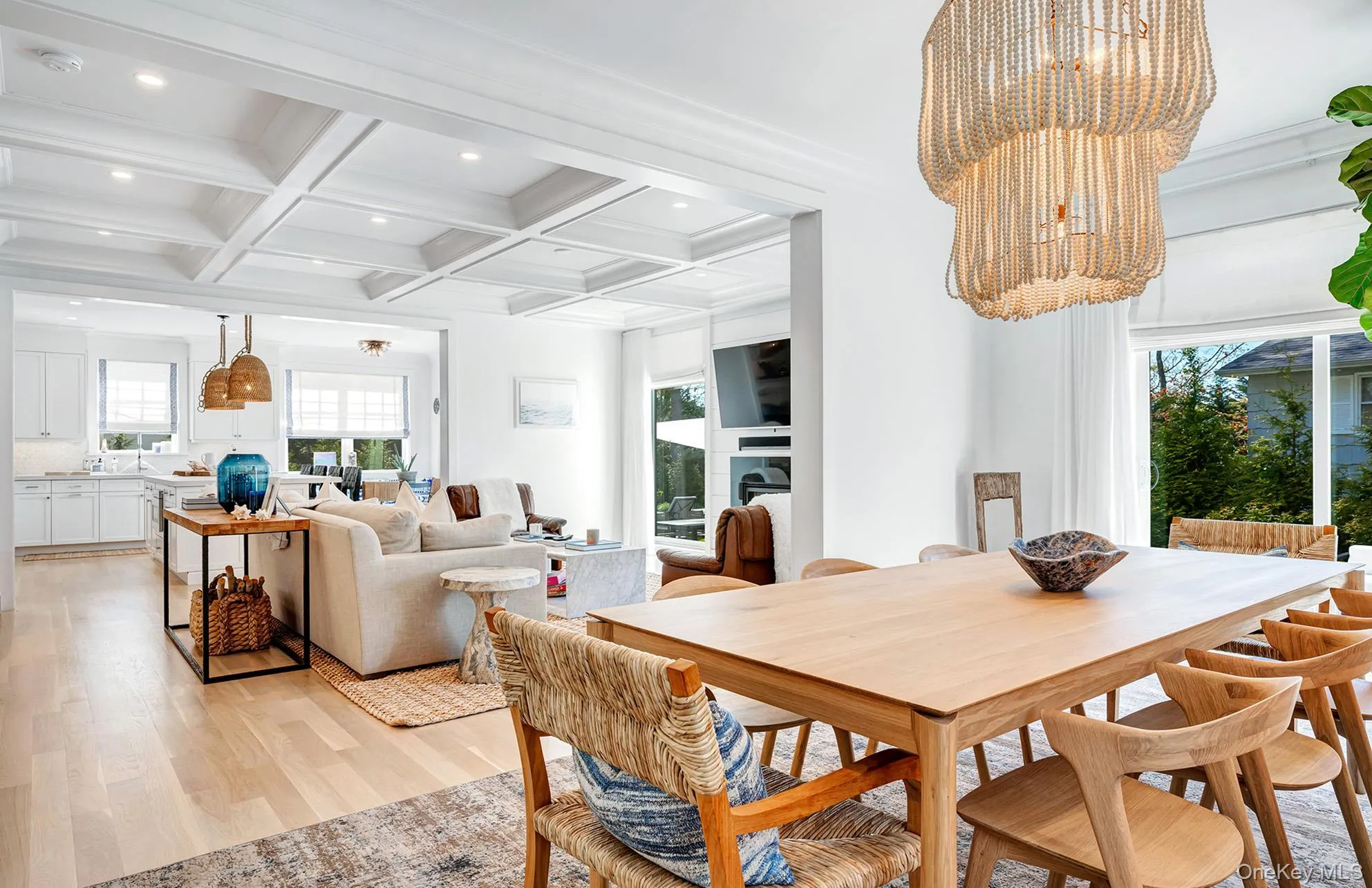 Dining space featuring coffered ceiling, beam ceiling, light hardwood / wood-style floors, and a chandelier Dining space featuring coffered ceiling, beam ceiling, light hardwood / wood-style floors, and a chandelier