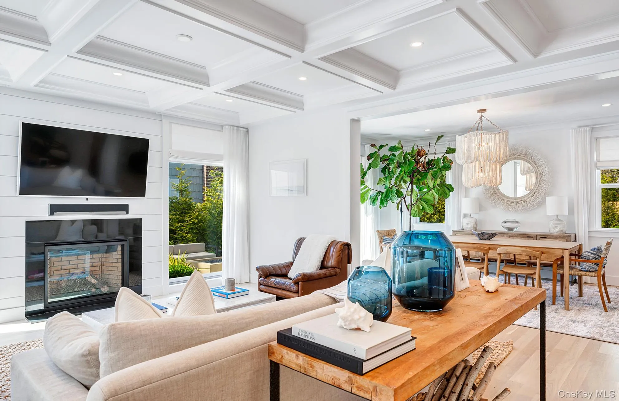 Living room with crown molding, wood-type flooring, coffered ceiling, and a wealth of natural light Living room with crown molding, wood-type flooring, coffered ceiling, and a wealth of natural light