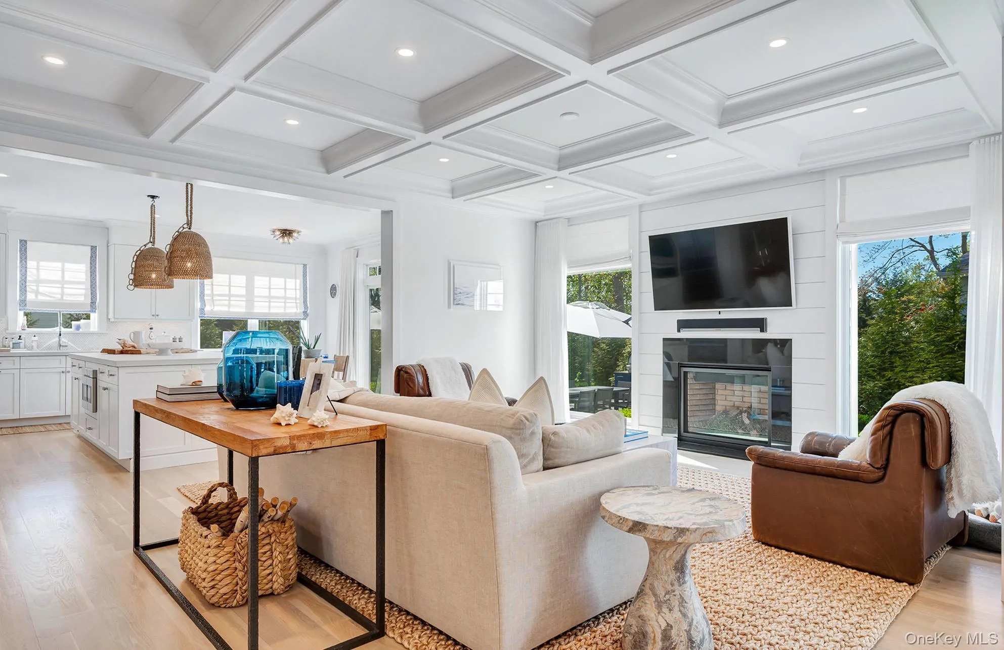 Living room featuring beamed ceiling, a fireplace, coffered ceiling, and light hardwood / wood-style floors Living room featuring beamed ceiling, a fireplace, coffered ceiling, and light hardwood / wood-style floors