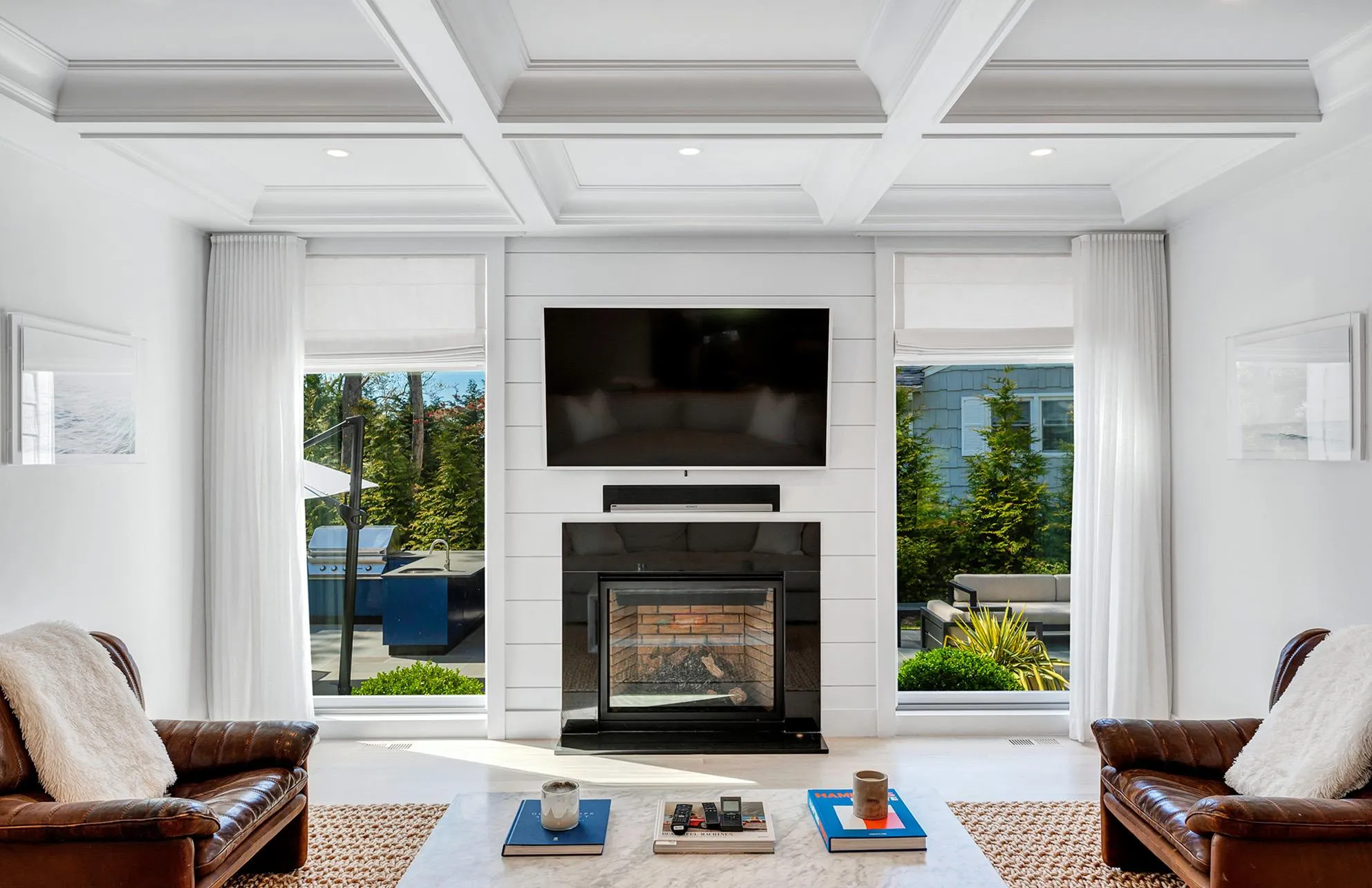 Living room featuring beamed ceiling, a large fireplace, ornamental molding, and coffered ceiling Living room featuring beamed ceiling, a large fireplace, ornamental molding, and coffered ceiling