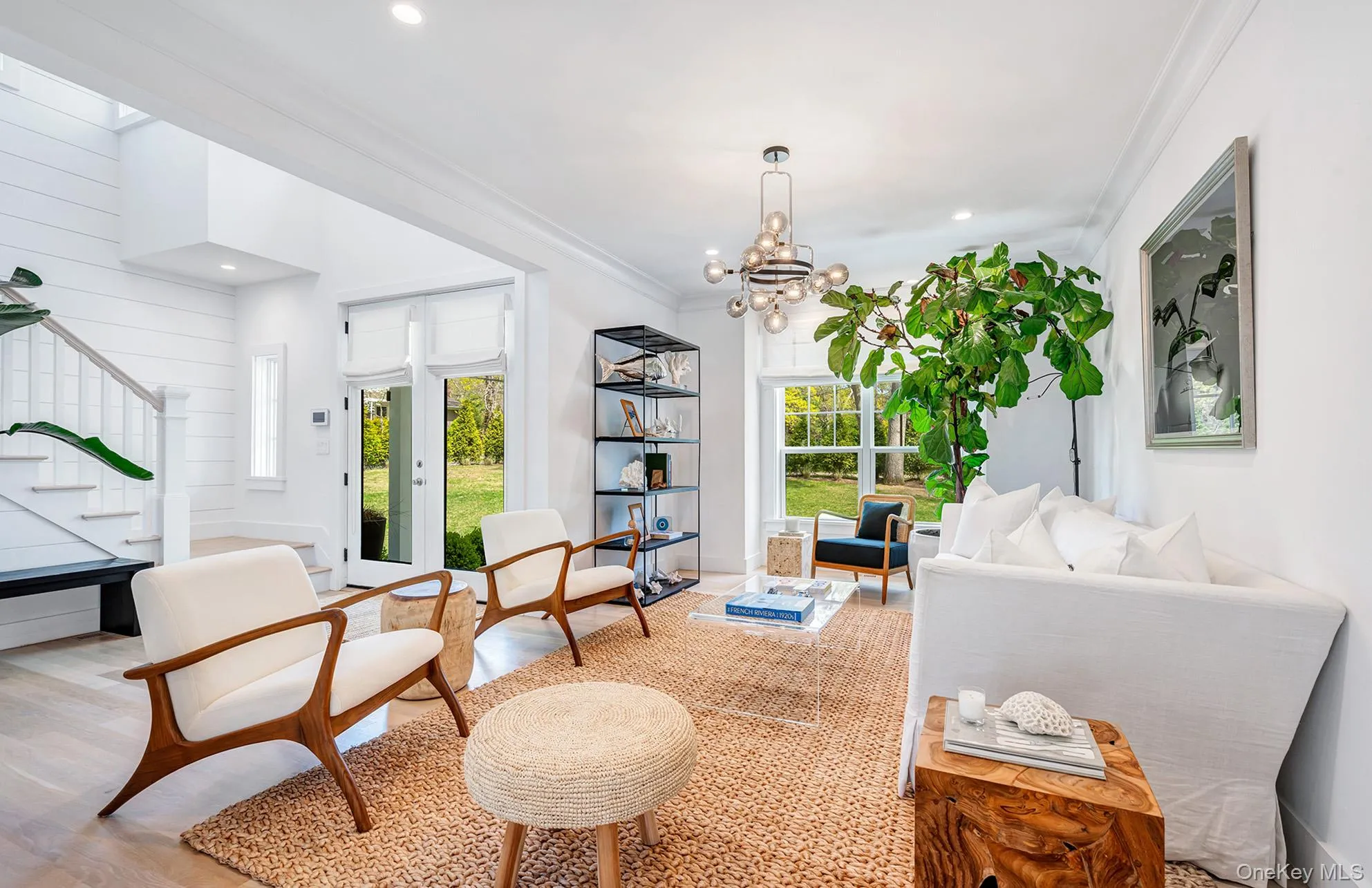 Living area featuring an inviting chandelier, crown molding, and light hardwood / wood-style floors Living area featuring an inviting chandelier, crown molding, and light hardwood / wood-style floors