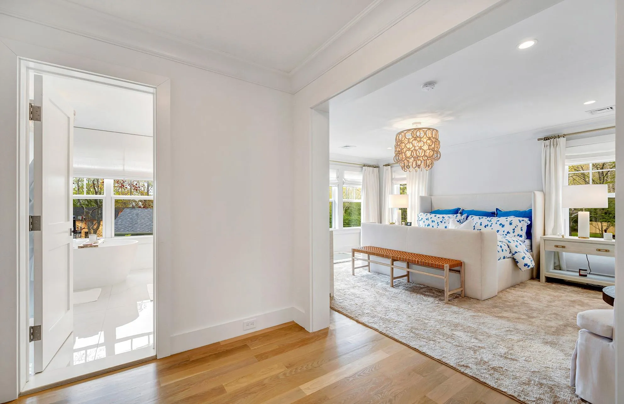 Bedroom with crown molding, wood-type flooring, multiple windows, and access to outside Bedroom with crown molding, wood-type flooring, multiple windows, and access to outside