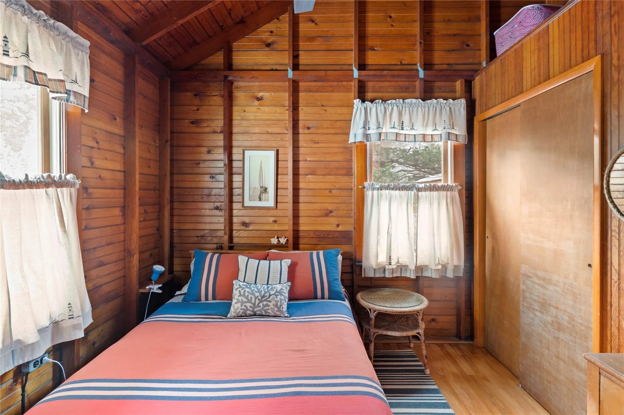 Bedroom with vaulted ceiling with beams, wooden ceiling, wooden walls, and light hardwood / wood-style flooring Bedroom with vaulted ceiling with beams, wooden ceiling, wooden walls, and light hardwood / wood-style flooring