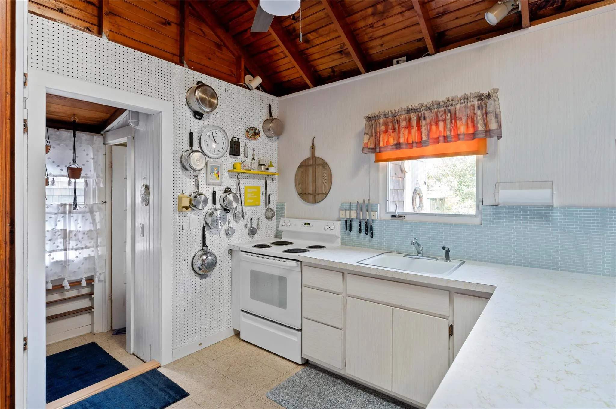 Kitchen featuring sink, wood ceiling, white electric range, white cabinetry, and lofted ceiling with beams Kitchen featuring sink, wood ceiling, white electric range, white cabinetry, and lofted ceiling with beams
