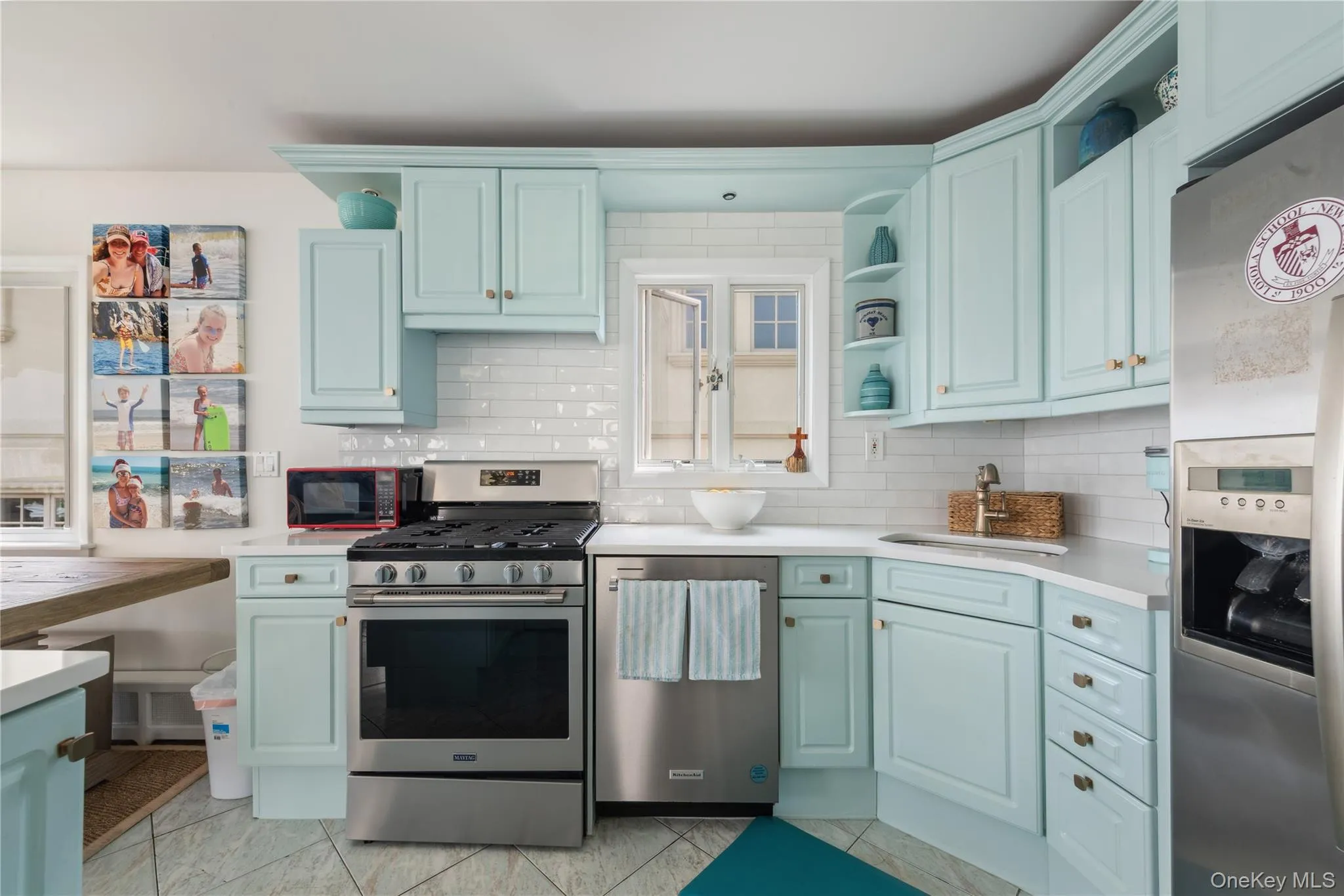 Kitchen with tasteful backsplash, appliances with stainless steel finishes, sink, and light tile patterned floors Kitchen with tasteful backsplash, appliances with stainless steel finishes, sink, and light tile patterned floors