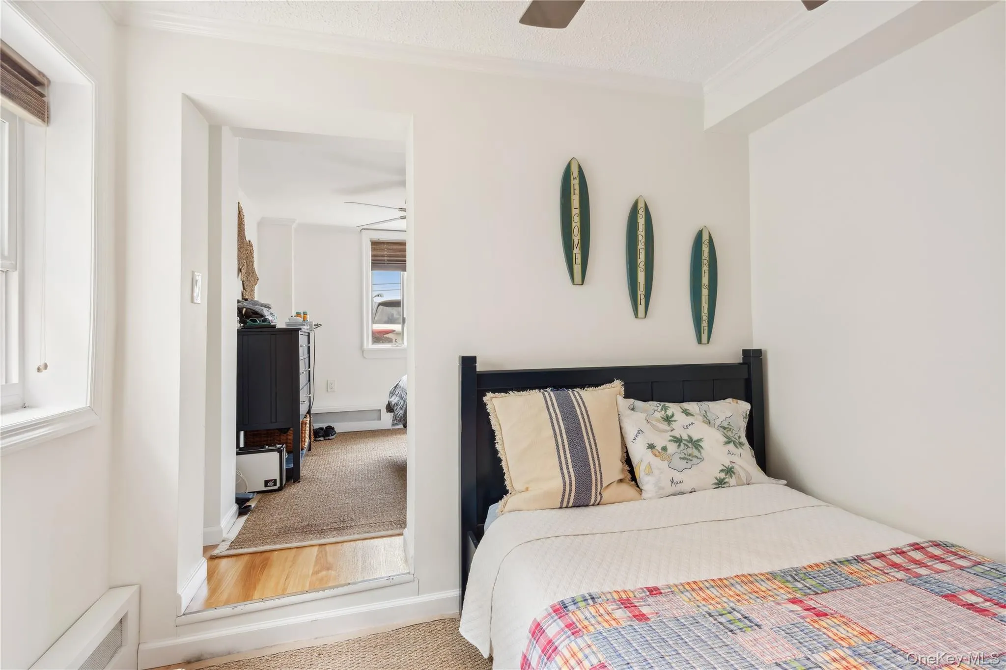 Carpeted bedroom featuring multiple windows, crown molding, a textured ceiling, and ceiling fan Carpeted bedroom featuring multiple windows, crown molding, a textured ceiling, and ceiling fan