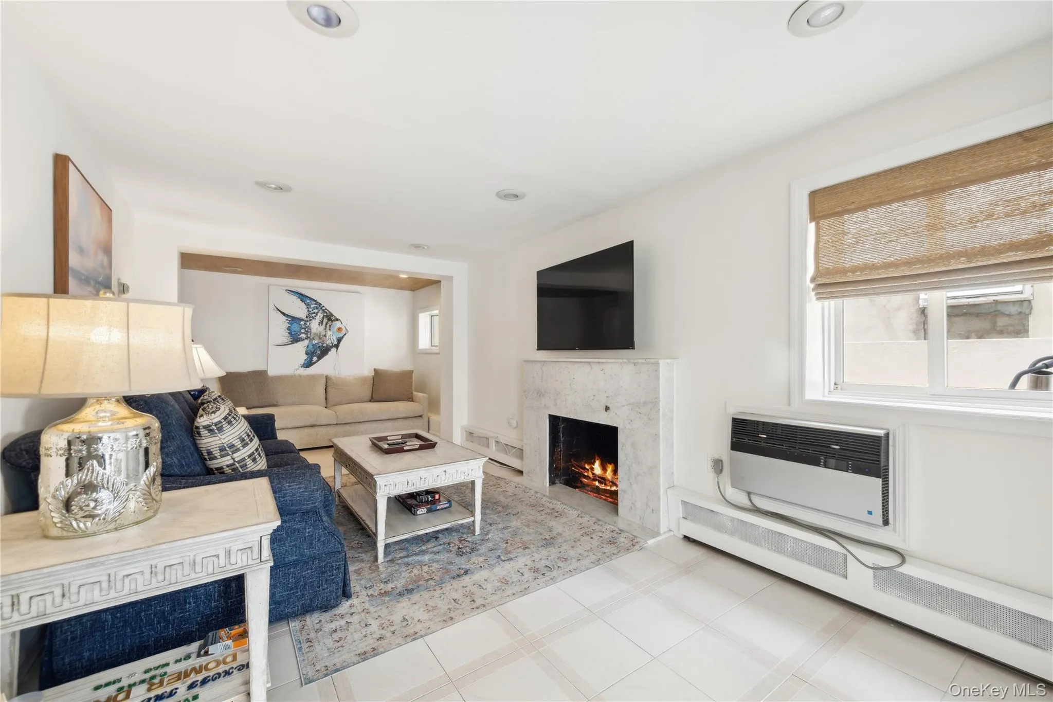 Living room with a baseboard radiator, heating unit, a wall mounted AC, and a fireplace Living room with a baseboard radiator, heating unit, a wall mounted AC, and a fireplace