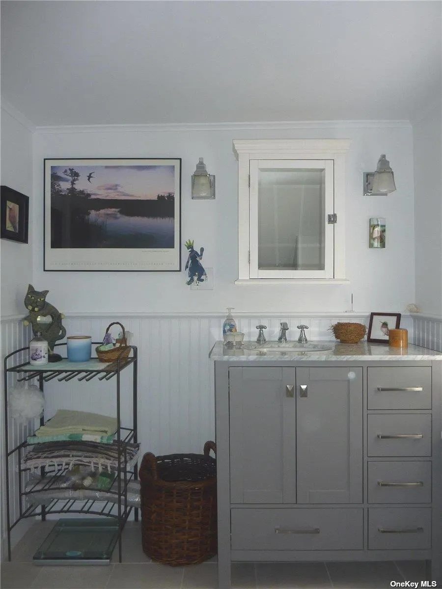 Bathroom featuring tile patterned flooring, ornamental molding, and vanity Bathroom featuring tile patterned flooring, ornamental molding, and vanity