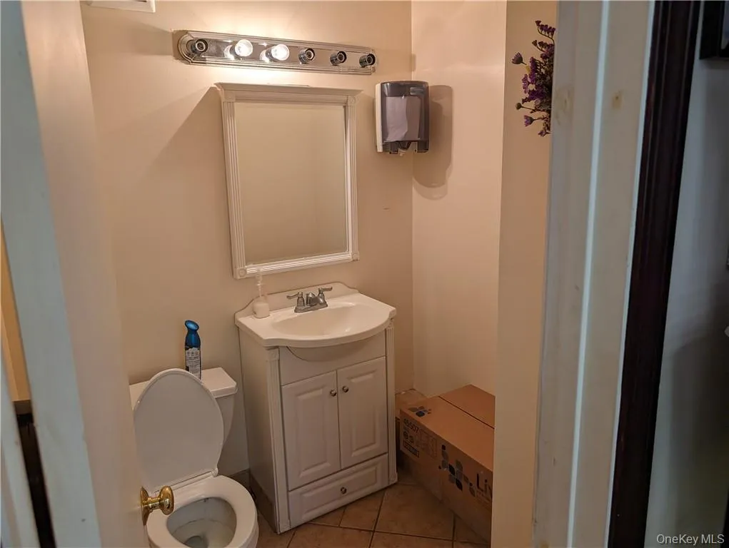 Bathroom with tile flooring, vanity with extensive cabinet space, and toilet Bathroom with tile flooring, vanity with extensive cabinet space, and toilet