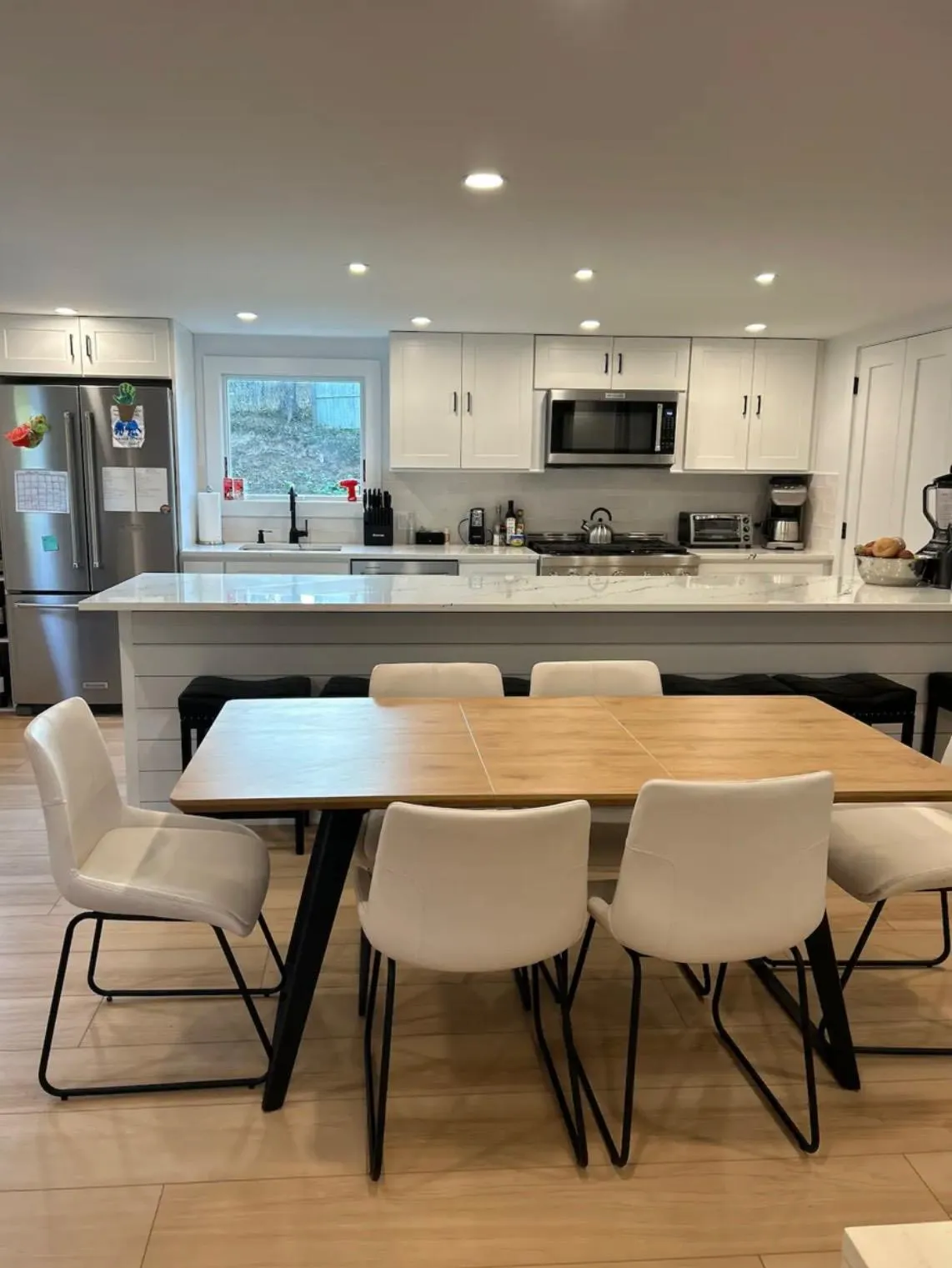 Kitchen featuring sink, stainless steel appliances, a kitchen breakfast bar, and white cabinets Kitchen featuring sink, stainless steel appliances, a kitchen breakfast bar, and white cabinets