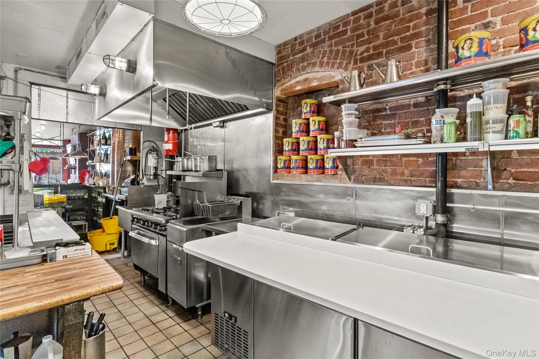 Kitchen with high end range, brick wall, and light tile patterned floors Kitchen with high end range, brick wall, and light tile patterned floors