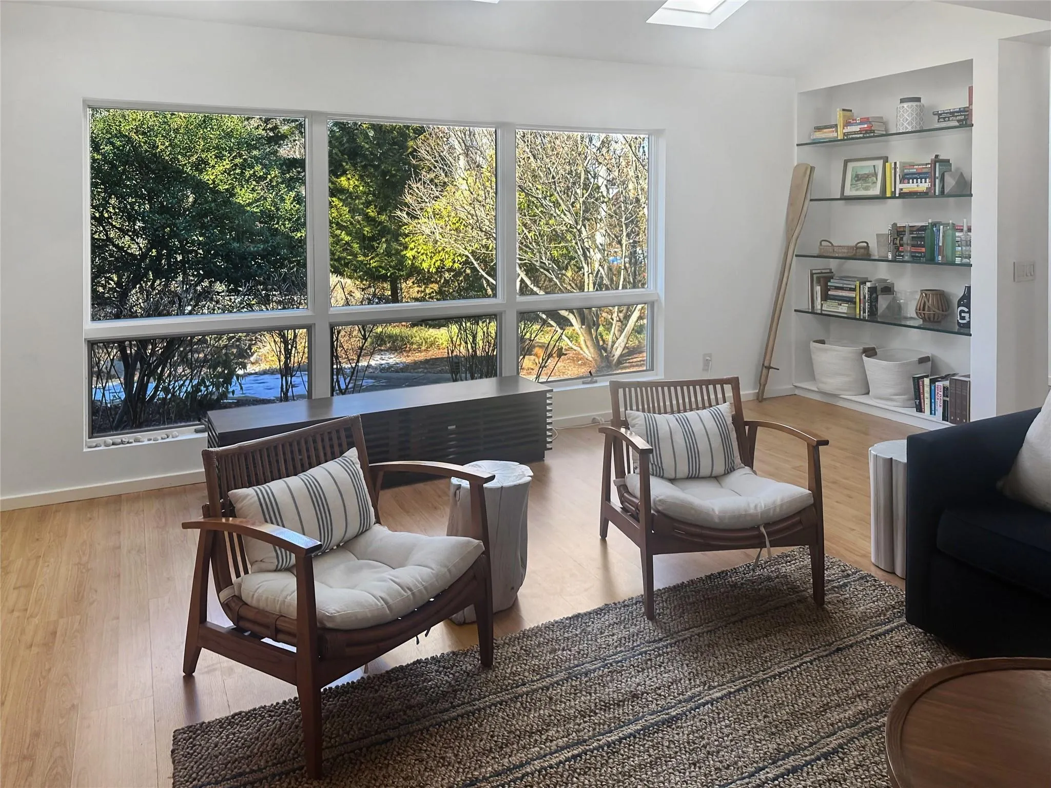 Sitting room with built in features, a skylight, and light hardwood / wood-style flooring Sitting room with built in features, a skylight, and light hardwood / wood-style flooring