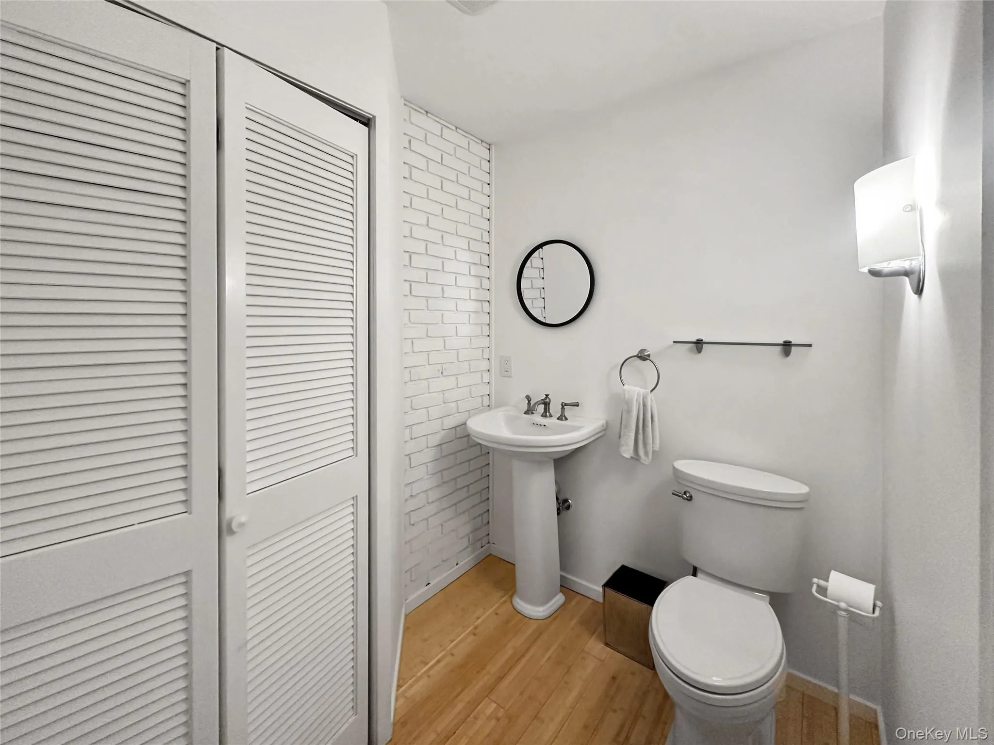 Bathroom with hardwood / wood-style flooring, toilet, and sink Bathroom with hardwood / wood-style flooring, toilet, and sink