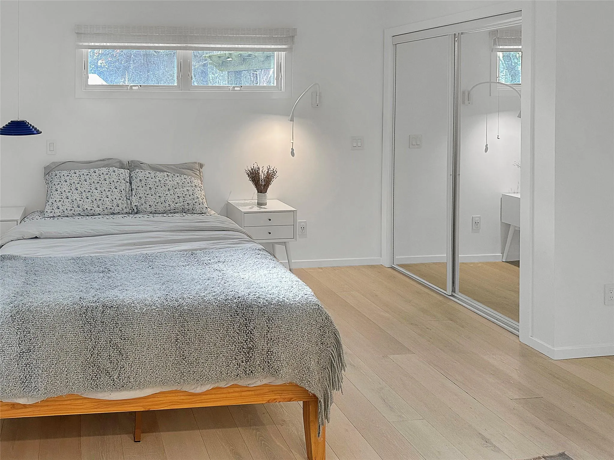 Bedroom featuring multiple windows, wood-type flooring, and a closet Bedroom featuring multiple windows, wood-type flooring, and a closet
