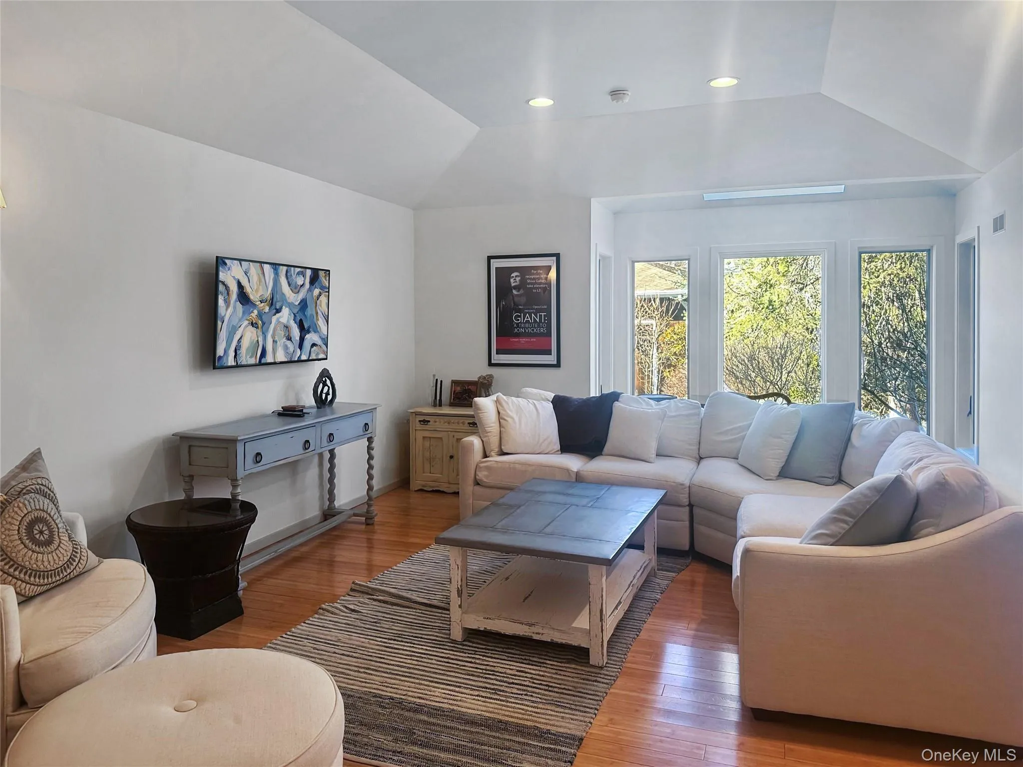 Living room with hardwood / wood-style flooring and vaulted ceiling Living room with hardwood / wood-style flooring and vaulted ceiling