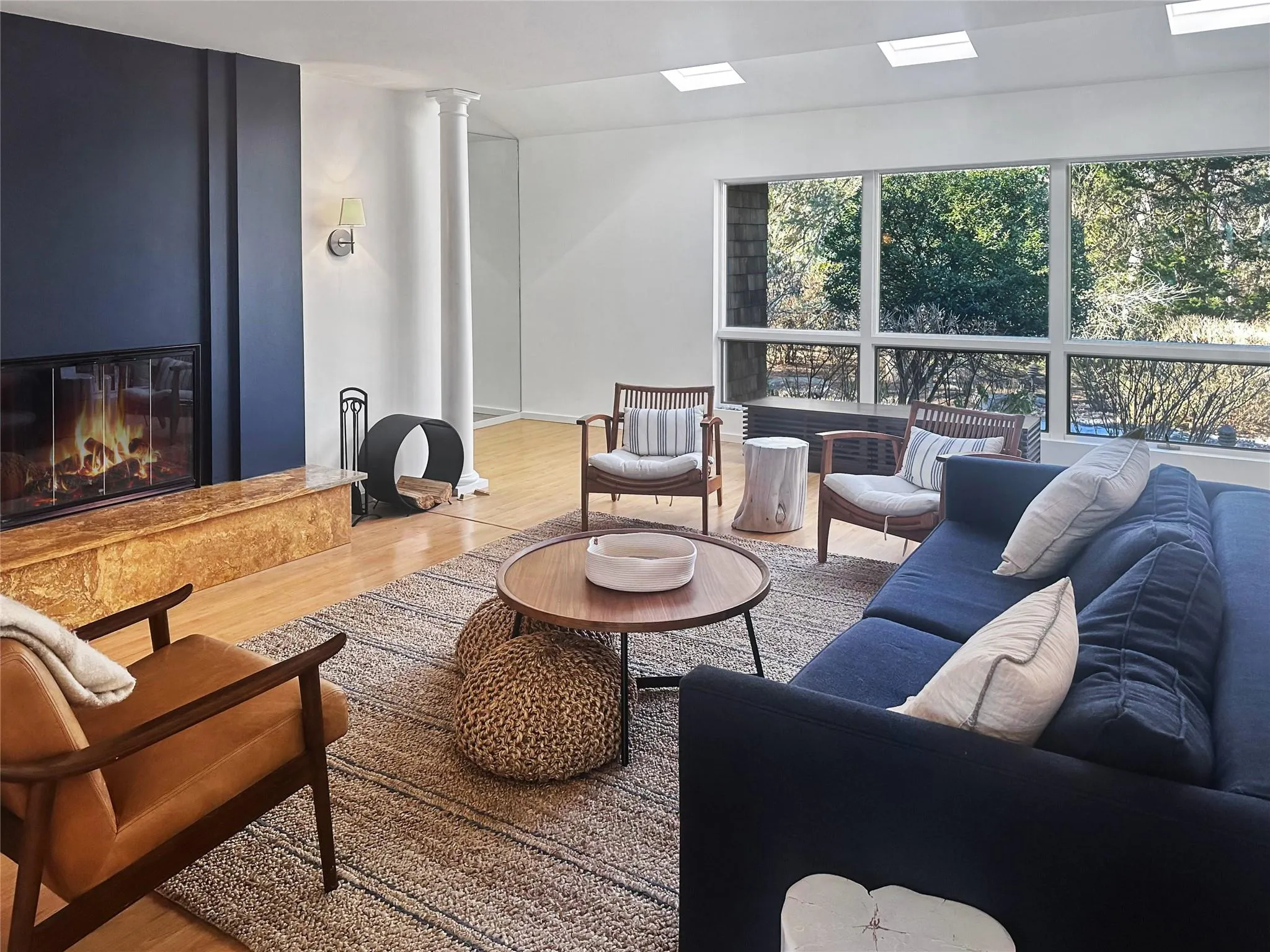 Living room with wood-type flooring, a fireplace, and decorative columns Living room with wood-type flooring, a fireplace, and decorative columns