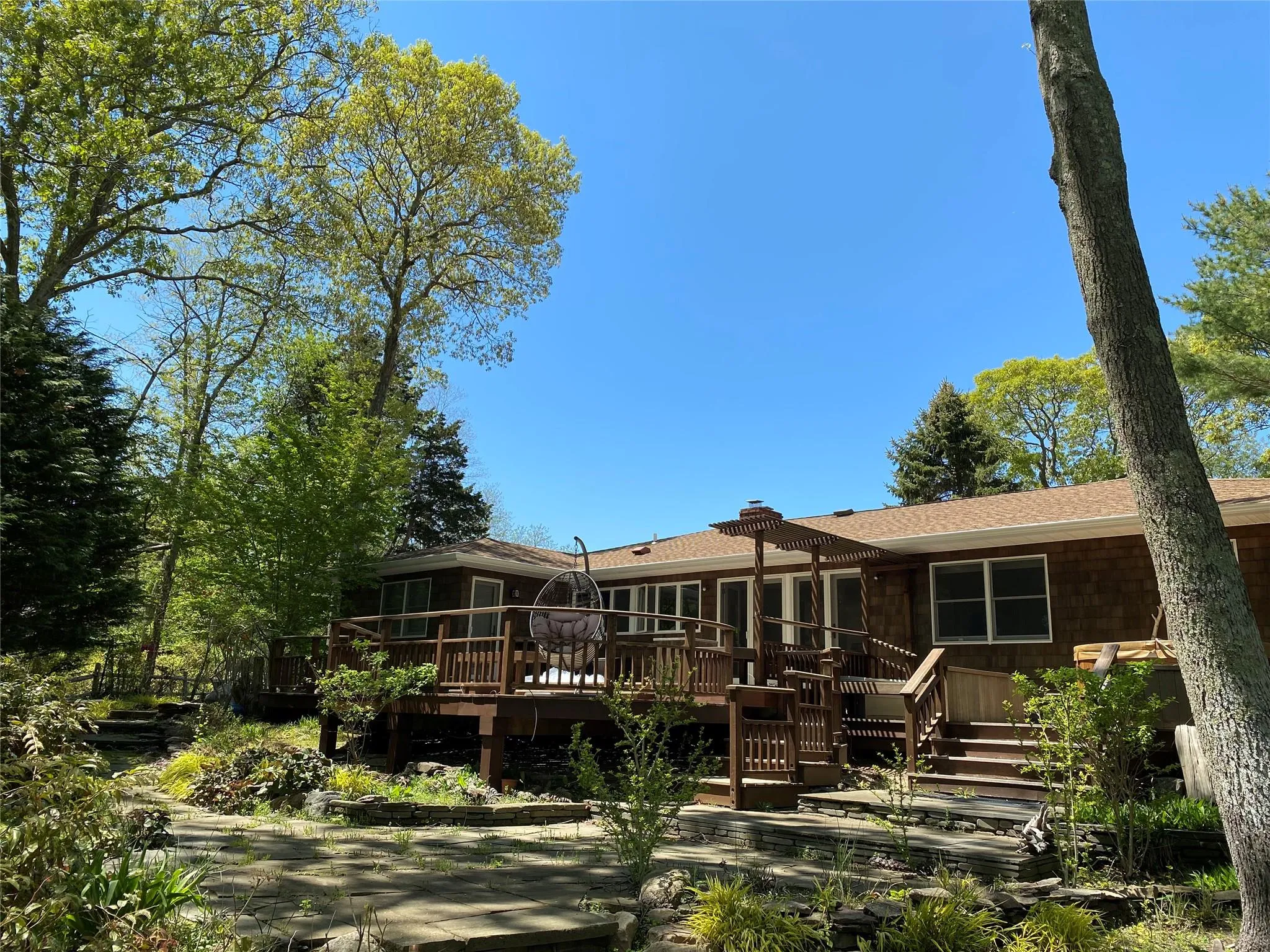 Rear view of property featuring a wooden deck and a sunroom Rear view of property featuring a wooden deck and a sunroom