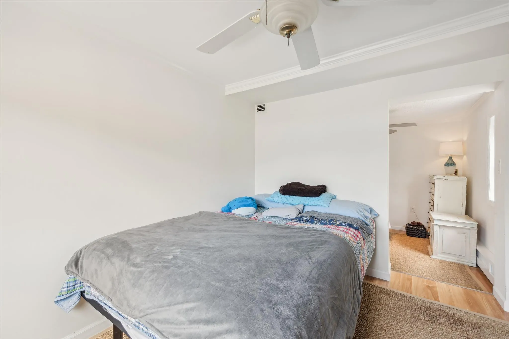 Bedroom featuring crown molding, light wood-type flooring, and ceiling fan Bedroom featuring crown molding, light wood-type flooring, and ceiling fan