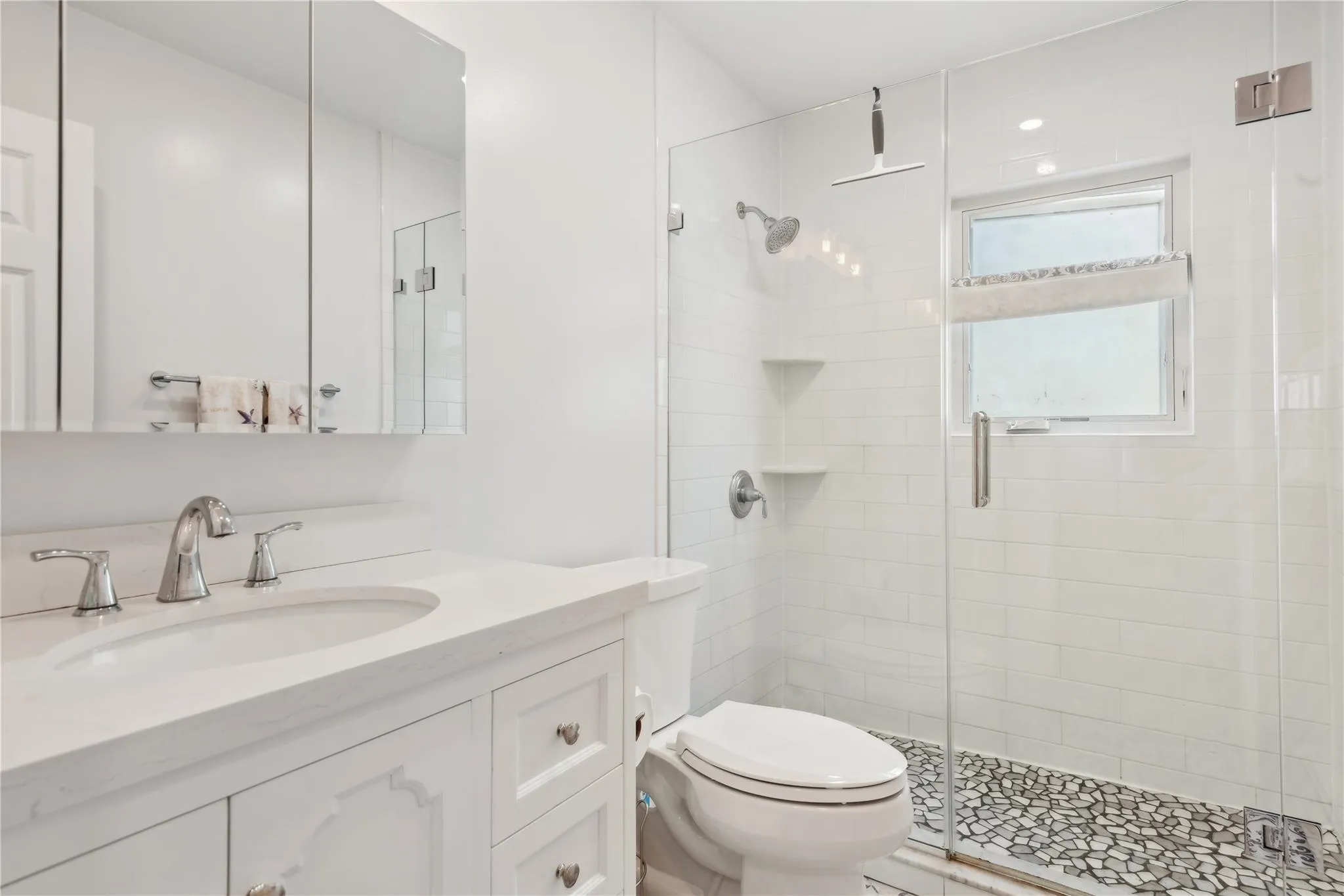 Bathroom featuring vanity, a shower with shower door, and toilet Bathroom featuring vanity, a shower with shower door, and toilet