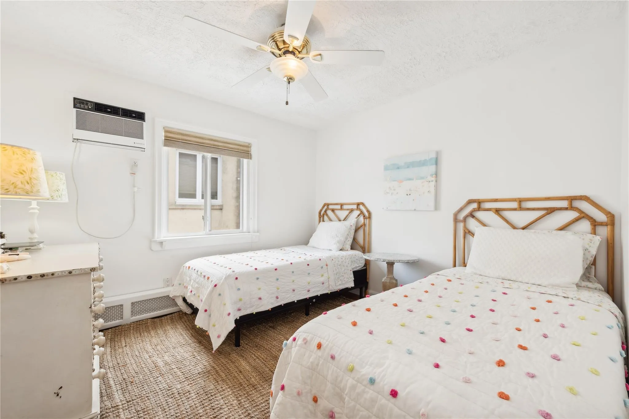Bedroom featuring a wall mounted AC, a textured ceiling, and ceiling fan Bedroom featuring a wall mounted AC, a textured ceiling, and ceiling fan