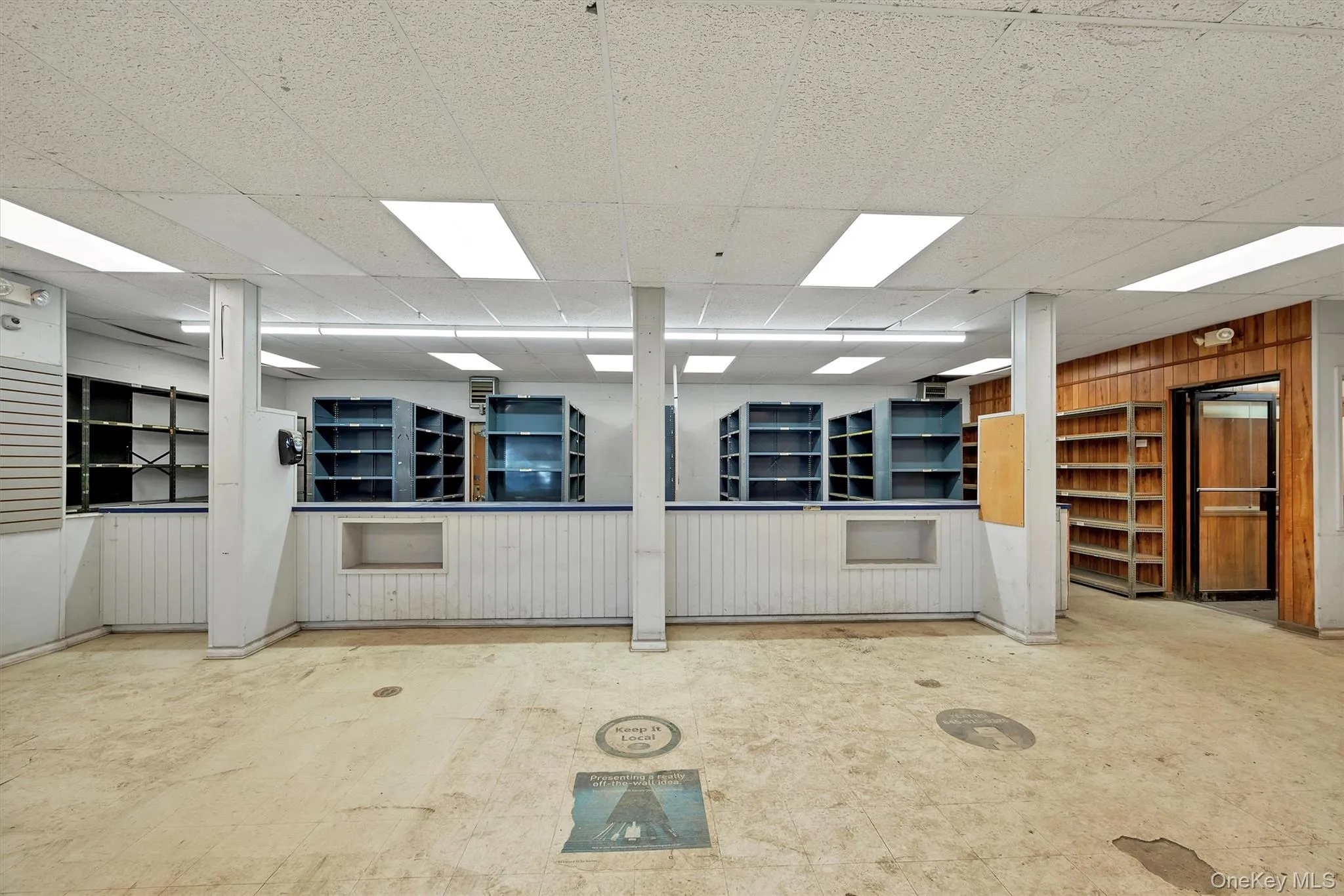 Unfurnished room with a drop ceiling and wood walls Unfurnished room with a drop ceiling and wood walls