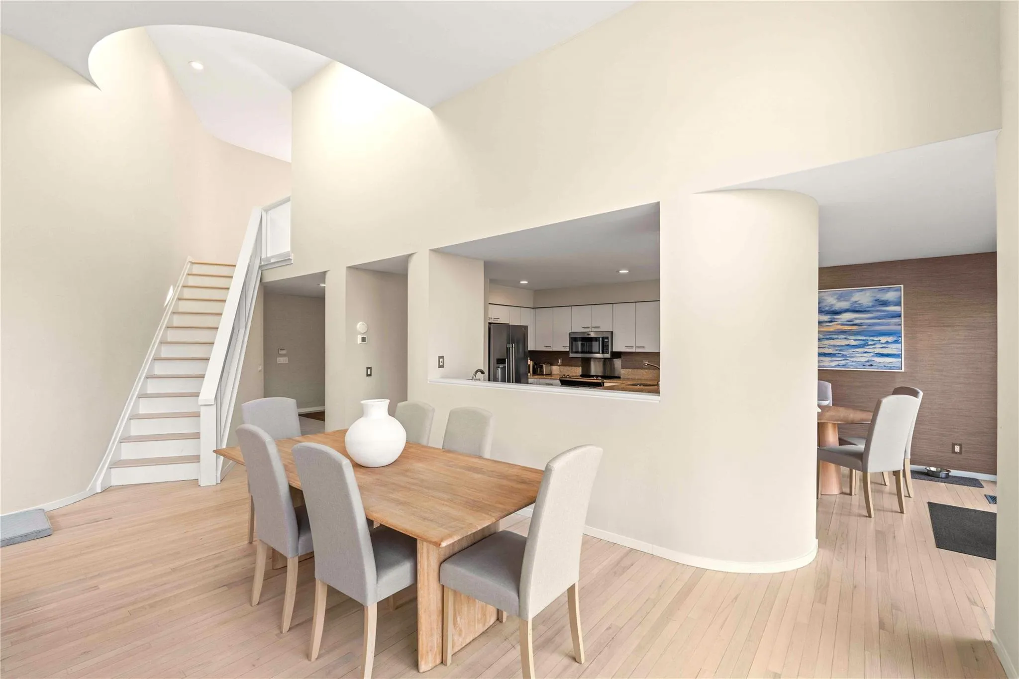 Dining area featuring a towering ceiling and light hardwood / wood-style flooring Dining area featuring a towering ceiling and light hardwood / wood-style flooring