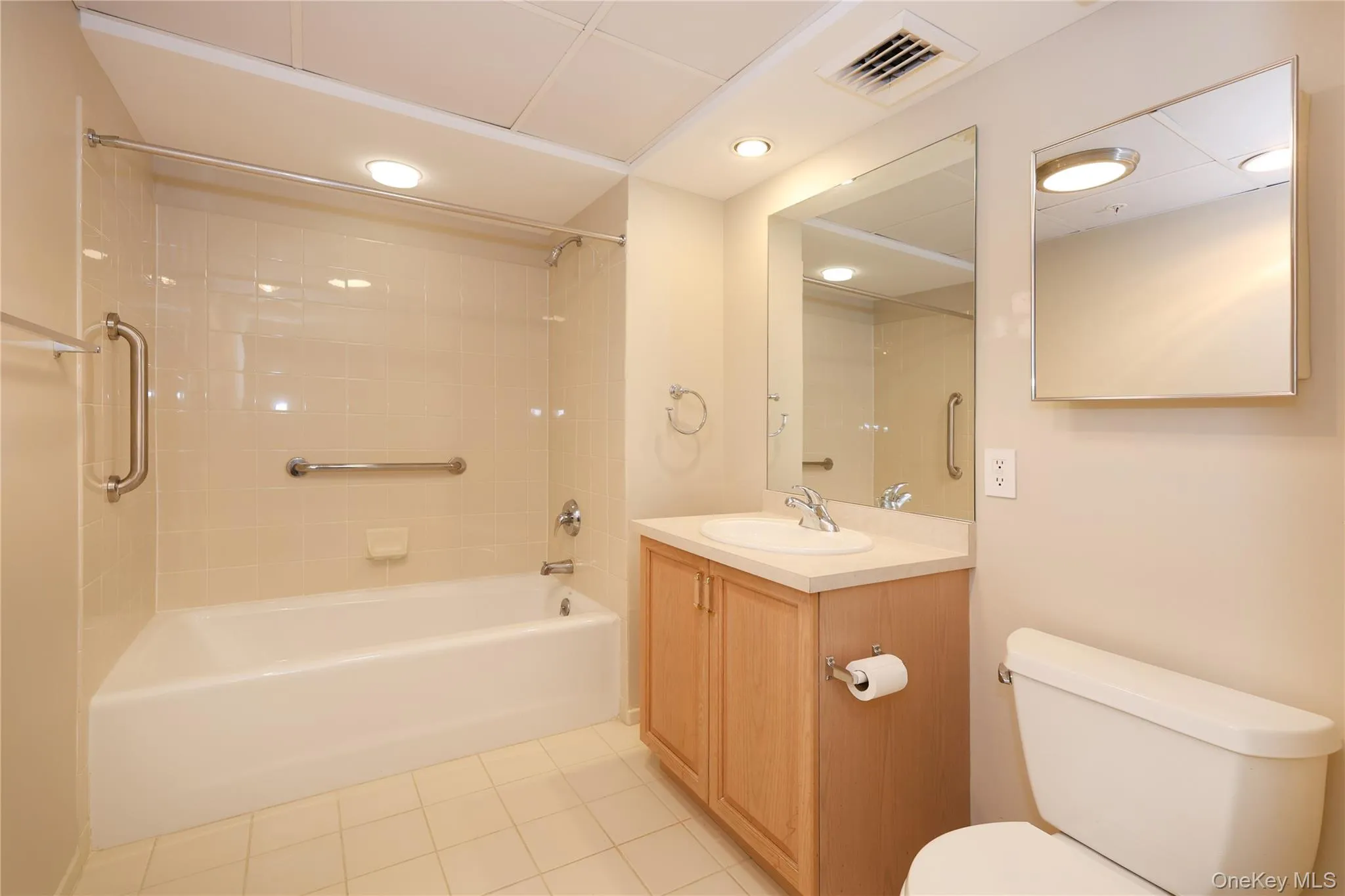 Bathroom featuring vanity, shower / bathtub combination, light tile patterned flooring, and recessed lighting Bathroom featuring vanity, shower / bathtub combination, light tile patterned flooring, and recessed lighting