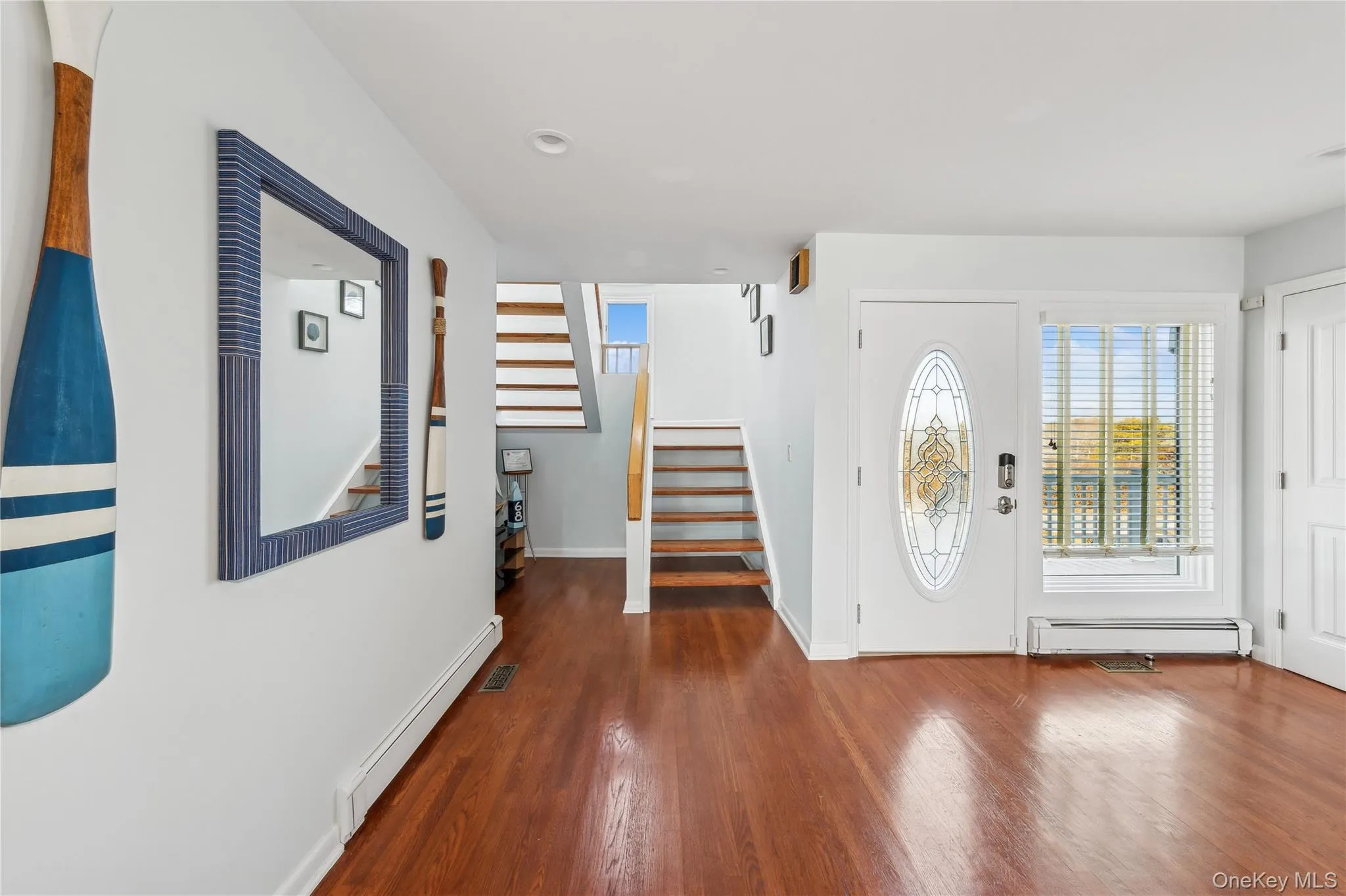 Entrance foyer featuring a baseboard radiator and dark hardwood / wood-style flooring Entrance foyer featuring a baseboard radiator and dark hardwood / wood-style flooring