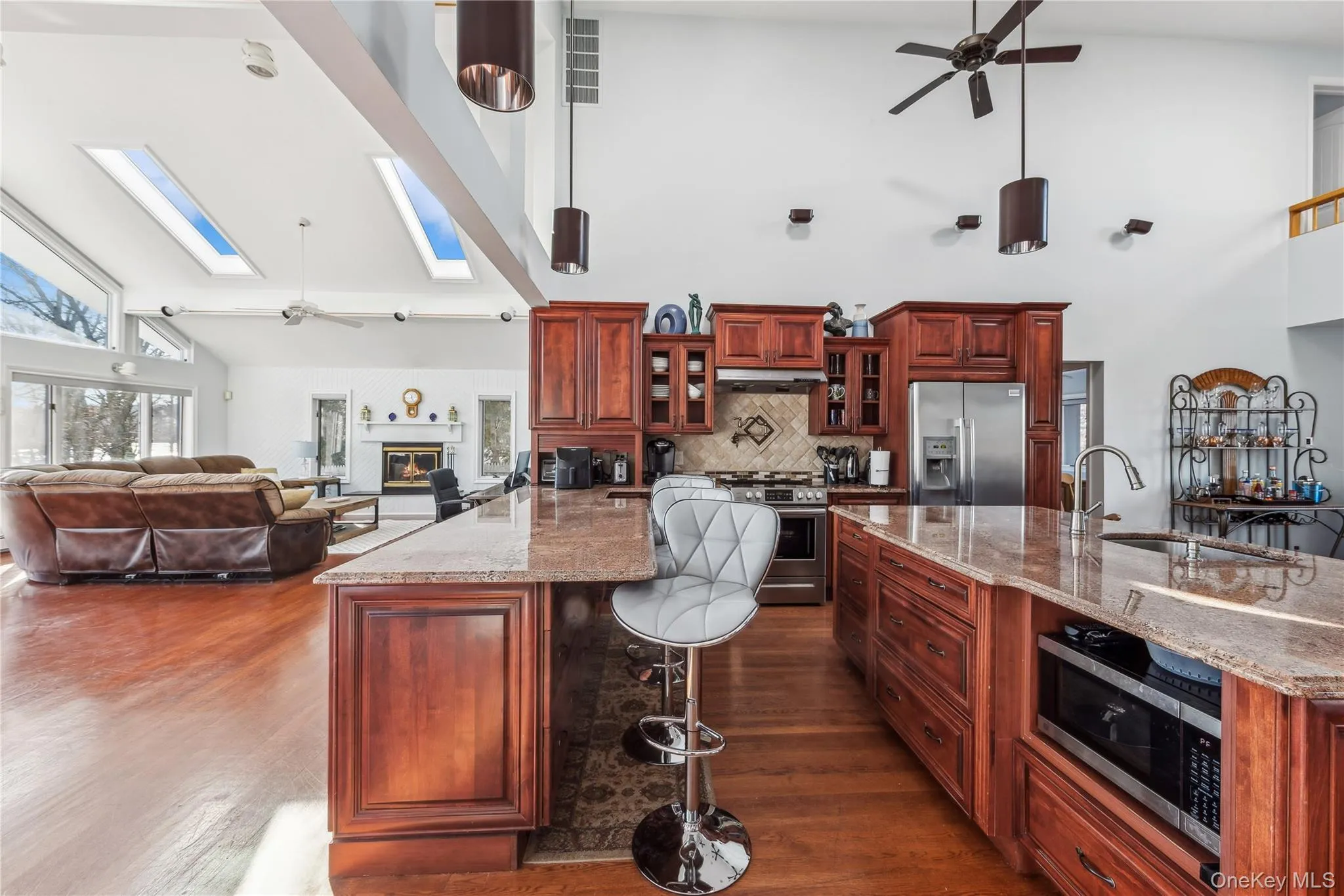 Kitchen featuring sink, a skylight, stainless steel appliances, and light stone countertops Kitchen featuring sink, a skylight, stainless steel appliances, and light stone countertops