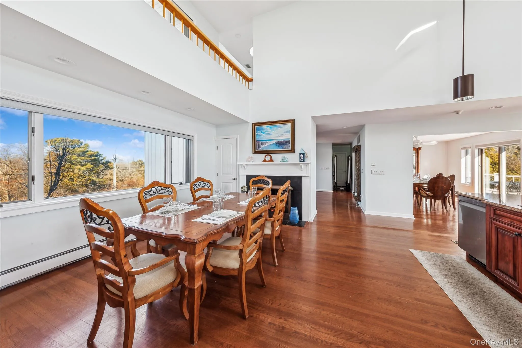 Dining space featuring dark hardwood / wood-style flooring, a baseboard radiator, and a high ceiling Dining space featuring dark hardwood / wood-style flooring, a baseboard radiator, and a high ceiling