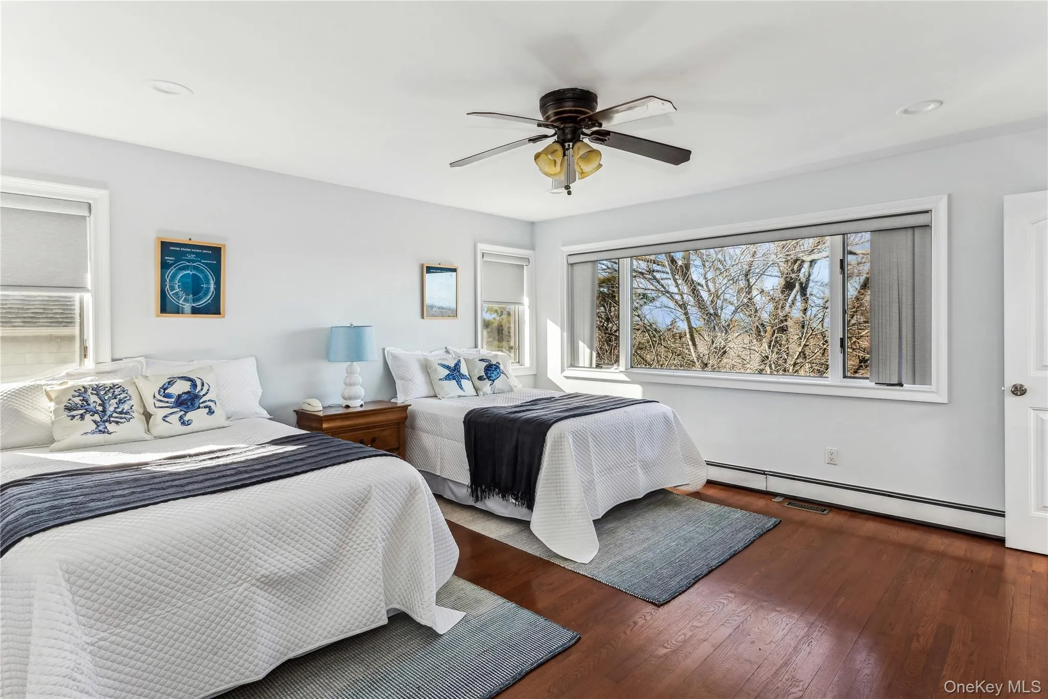 Bedroom featuring ceiling fan, dark wood-type flooring, and baseboard heating Bedroom featuring ceiling fan, dark wood-type flooring, and baseboard heating